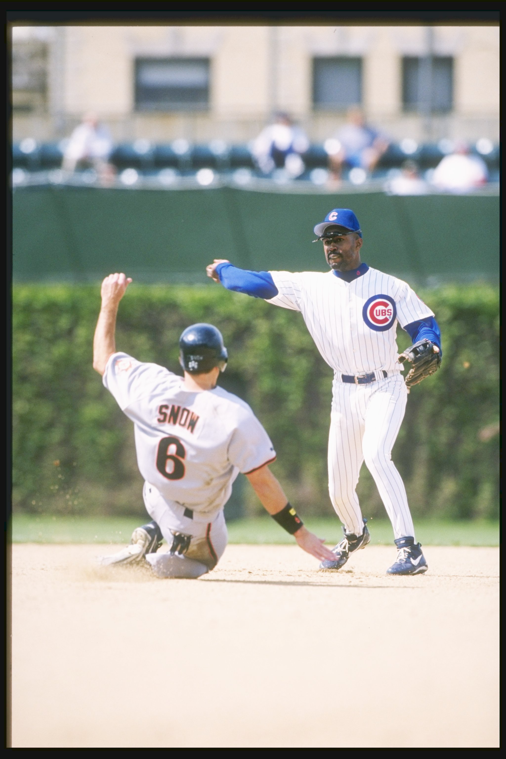 19 May 1997: Shortstop Shawn Dunston of the Chicago Cubs throws the ball as first baseman J.T. Snow of the San Francisco Giants slides at Wrigley Field in Chicago, Illinois. The Cubs won the game 15-4.