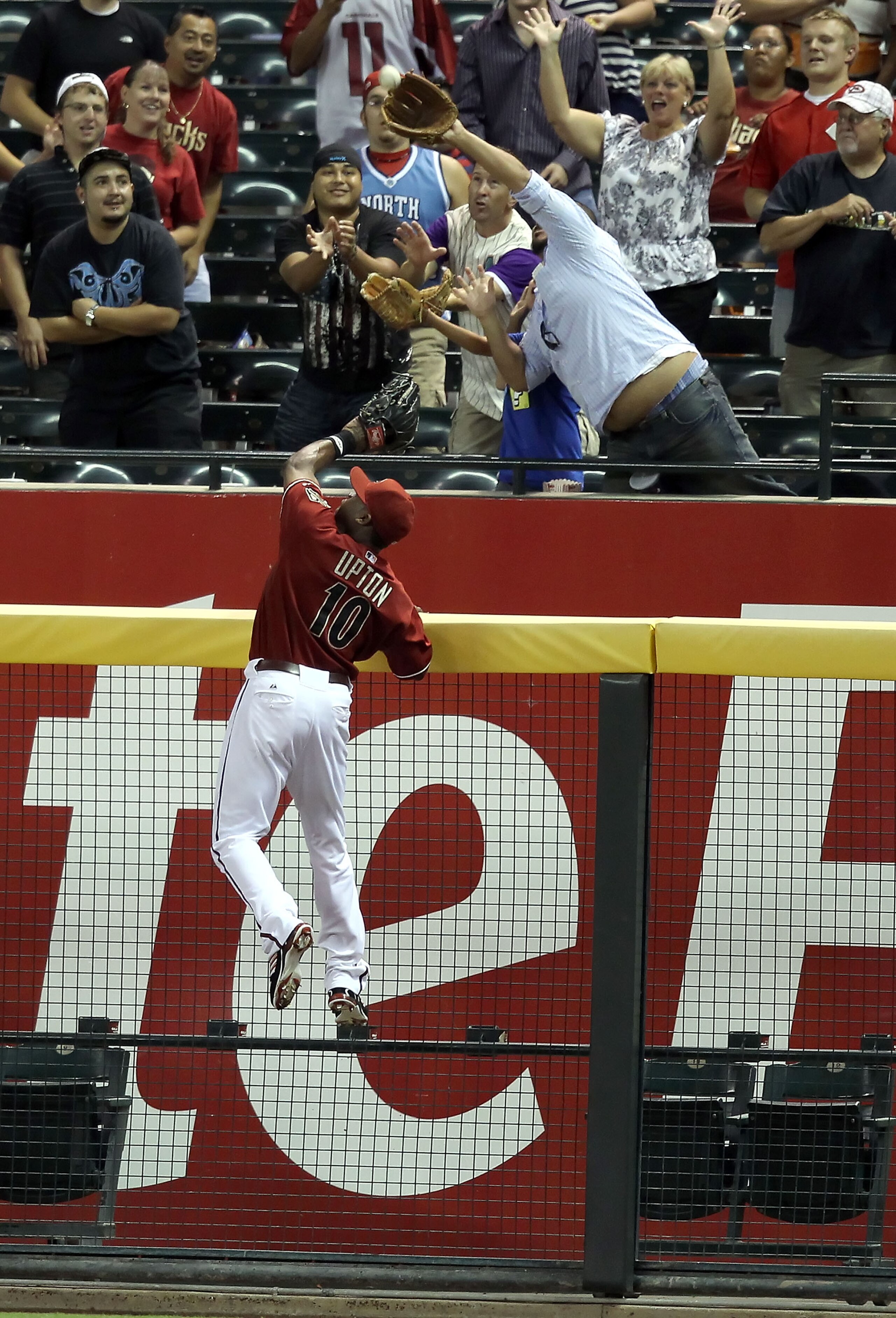 PHOENIX - AUGUST 18: Outfielder Justin Upton #10 of the Arizona Diamondbacks attempts to catch a home run hit by Jay Bruce (not pictured) of the Cincinnati Reds during the fourth inning of the Major League Baseball game at Chase Field on August 18, 2010 PHOENIX - AUGUST 18: Outfielder Justin Upton #10 of the Arizona Diamondbacks attempts to catch a home run hit by Jay Bruce (not pictured) of the Cincinnati Reds during the fourth inning of the Major League Baseball game at Chase Field on August 18, 2010