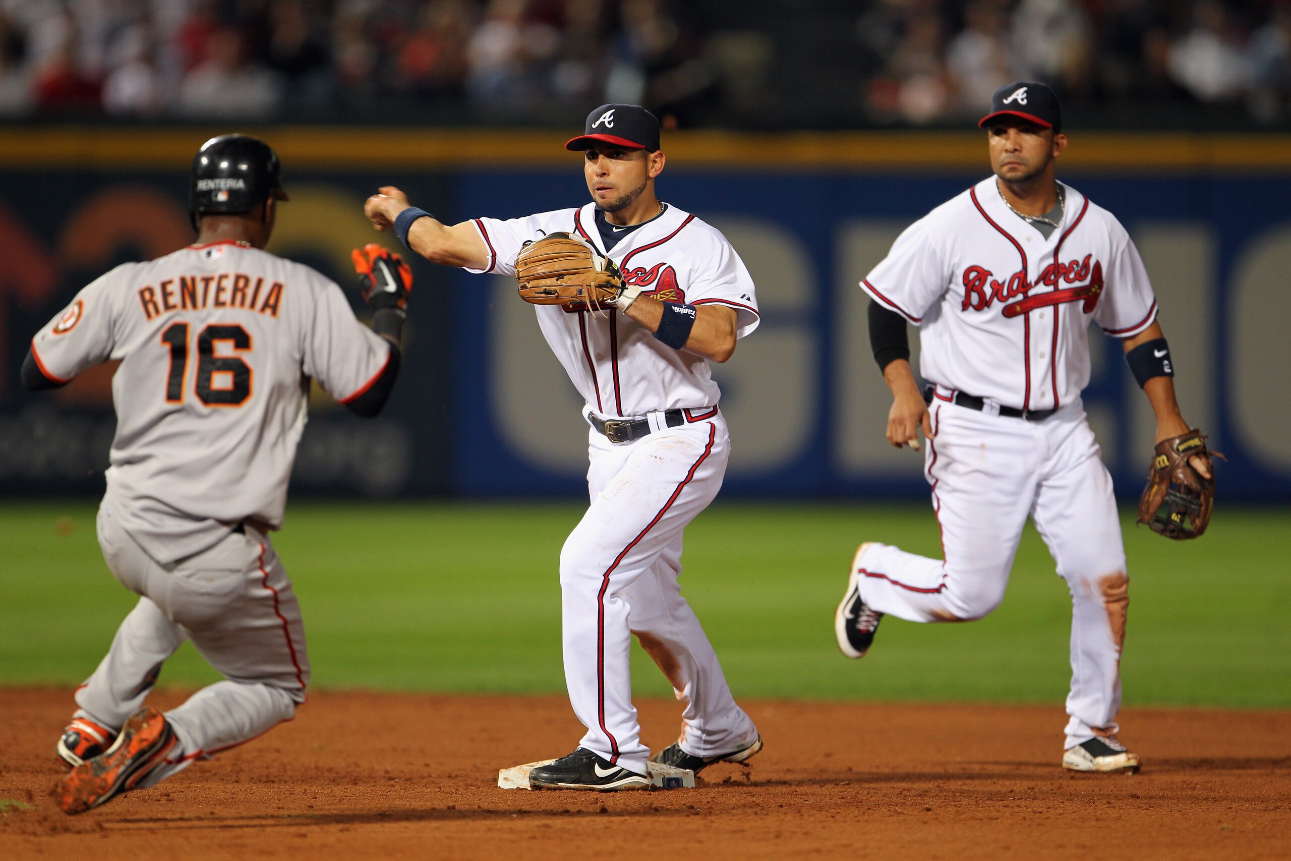 ATLANTA - OCTOBER 11: Omar Infante #4 of the Atlanta Braves turns a double play as Edgar Renteria #16 the San Francisco Giants approaches second during the 8th inning of Game Four of the NLDS of the 2010 MLB Playoffs on October 11, 2010 at Turner Field ATLANTA - OCTOBER 11: Omar Infante #4 of the Atlanta Braves turns a double play as Edgar Renteria #16 the San Francisco Giants approaches second during the 8th inning of Game Four of the NLDS of the 2010 MLB Playoffs on October 11, 2010 at Turner Field