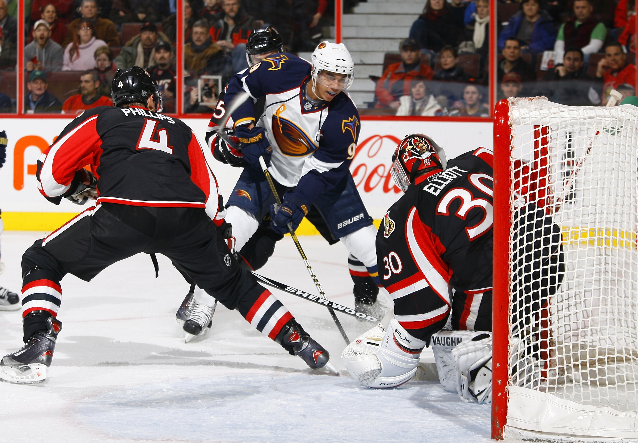 OTTAWA, ON - DECEMBER 13:  Evander Kane #9 of the Atlanta Thrashers takes the puck hard to the net against Chris Phillips #4;Sergei Gonchar #55 and Brian Elliott #30 of the Ottawa Senators in a game at Scotiabank Place on December 13, 2010 in Ottawa, Cana