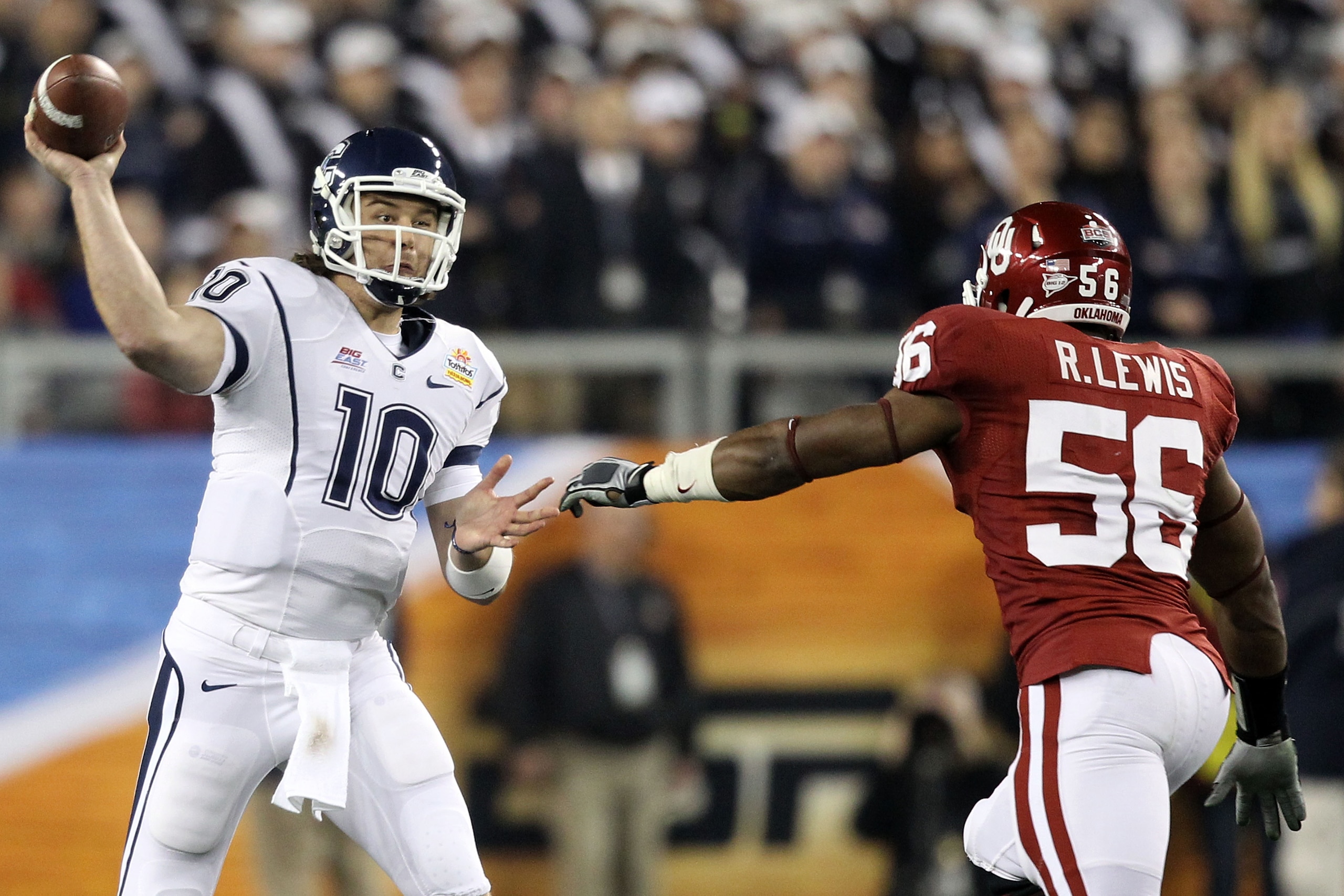 GLENDALE, AZ - JANUARY 01:  Zach Frazer #10 of the Connecticut Huskies attempts to throw the ball over Ronnell Lewis #56 of the Oklahoma Sooners in the first half in the Tostitos Fiesta Bowl at the Universtity of Phoenix Stadium on January 1, 2011 in Glen