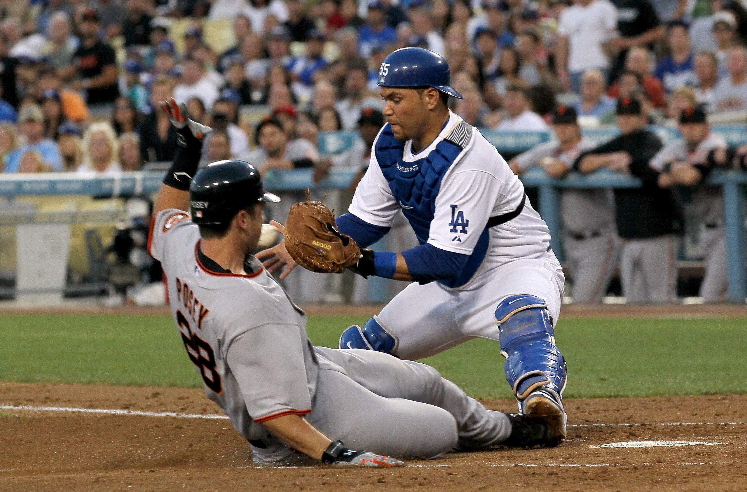 LOS ANGELES - JULY 19:  Buster Posey #28 of the San Francisco Giants slides safely into home with a run as catcher Russell Martin #55 of the Los Angeles Dodgers takes the throw in the third inning on July 19, 2010 at Dodger Stadium in Los Angeles, Califor