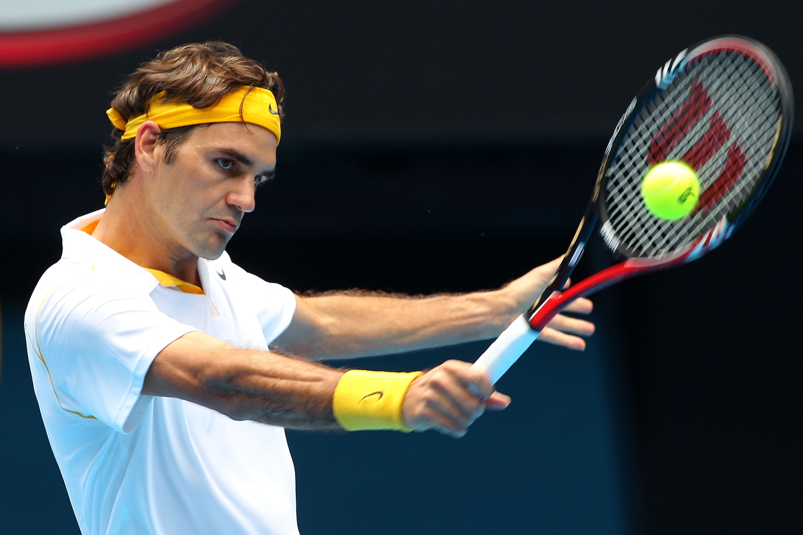 MELBOURNE, AUSTRALIA - JANUARY 25:  Roger Federer of Switzerland plays a backhand in his quarterfinal match against Stanislas Wawrinka of Switzerland during day nine of the 2011 Australian Open at Melbourne Park on January 25, 2011 in Melbourne, Australia