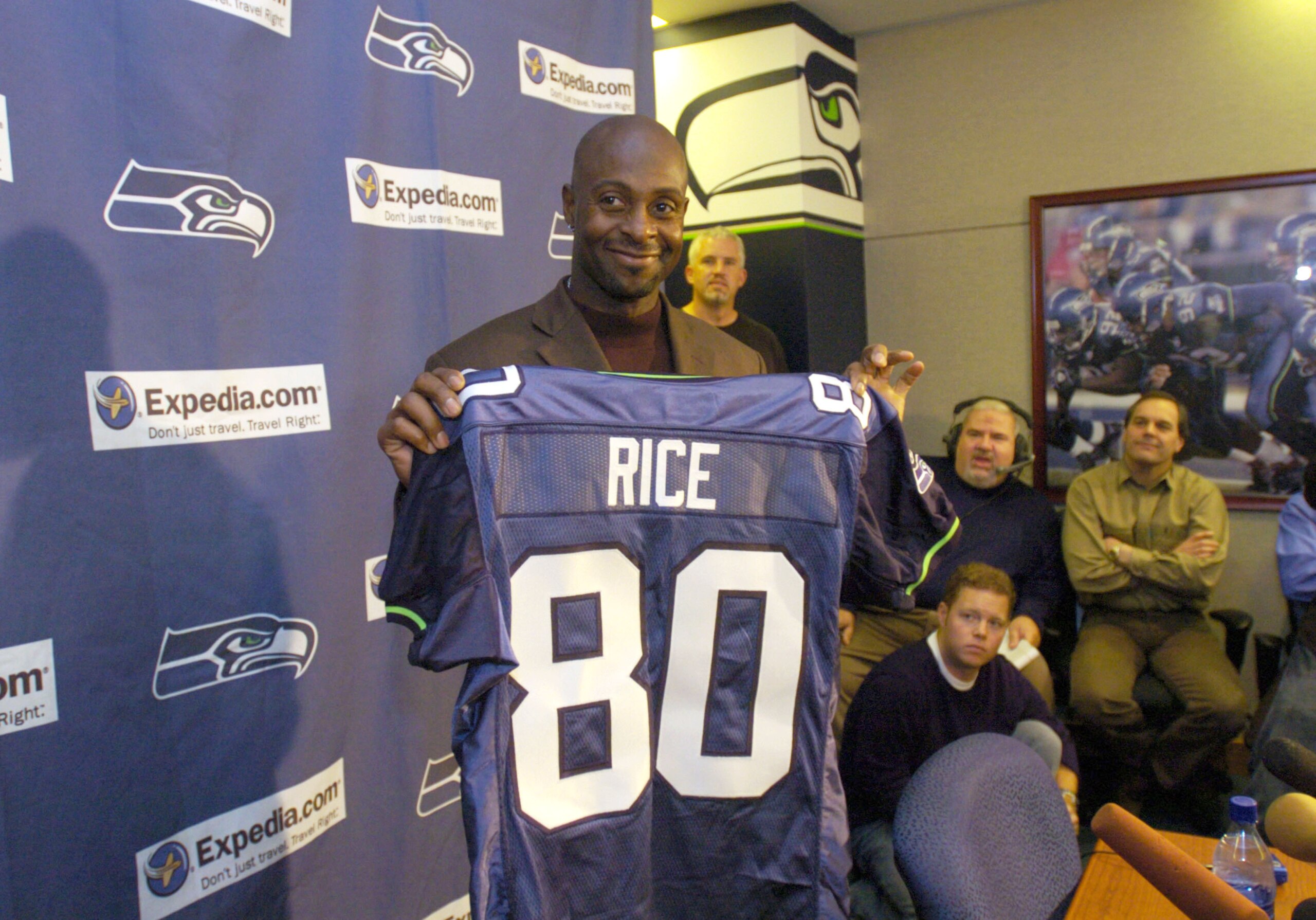 KIRKLAND, WA - OCTOBER 19:  Receiver Jerry Rice #80 (C) holds up his new Seattle Seahawks jersey after the Seattle Seahawks announced a trade on October 19, 2004 with the Oakland Raiders in Kirkland, Washington. The Oakland Raiders traded Rice to the Seat