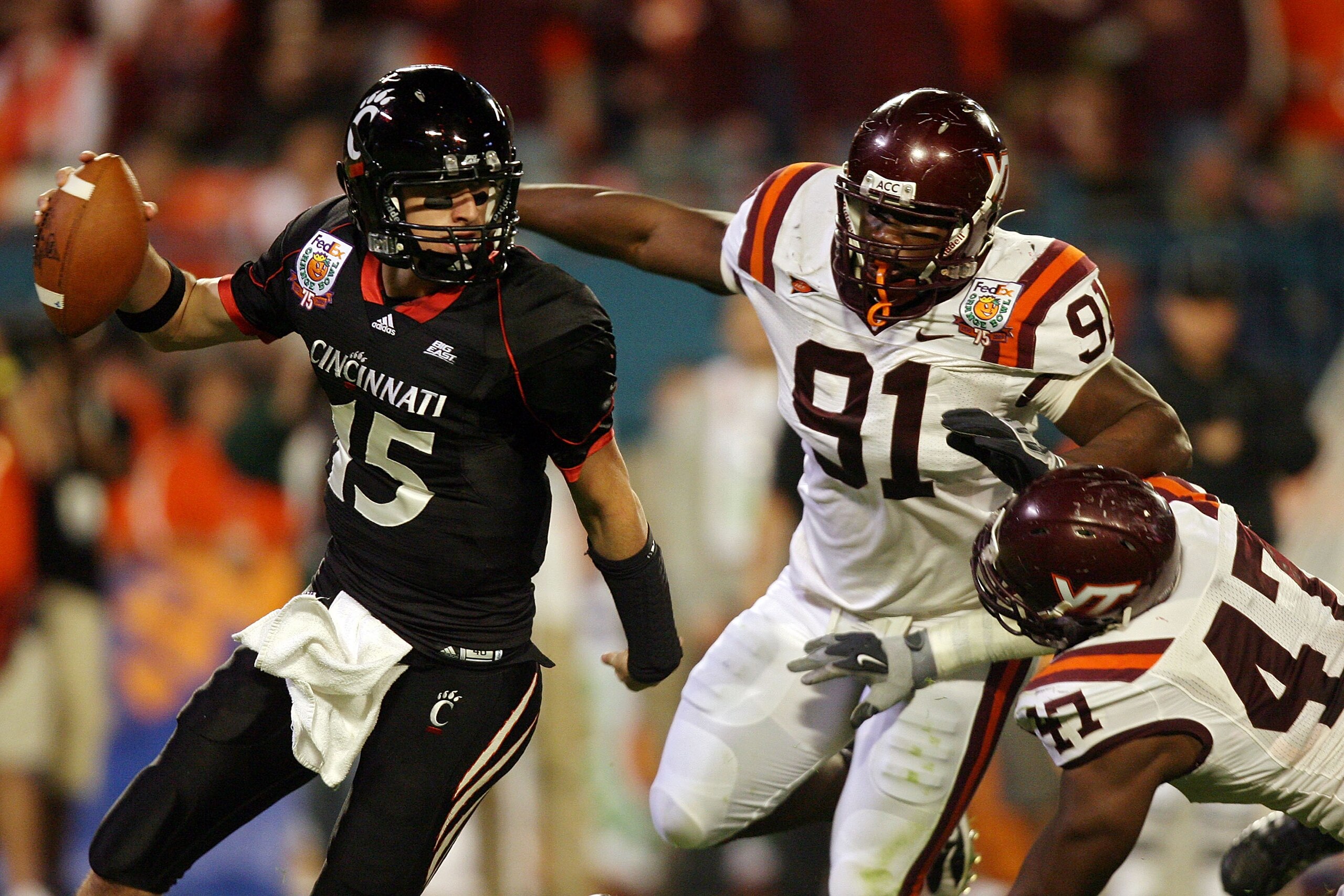 MIAMI - JANUARY 01: Tony Pike #15 of the Cincinnati Bearcats scambles away from Nekos Brown #47 and John Graves #91 of the Virginia Tech Hokies during the FedEx Orange Bowl at Dolphin Stadium on January 1, 2009 in Miami, Florida. (Photo by Doug Benc/Get MIAMI - JANUARY 01: Tony Pike #15 of the Cincinnati Bearcats scambles away from Nekos Brown #47 and John Graves #91 of the Virginia Tech Hokies during the FedEx Orange Bowl at Dolphin Stadium on January 1, 2009 in Miami, Florida. (Photo by Doug Benc/Get