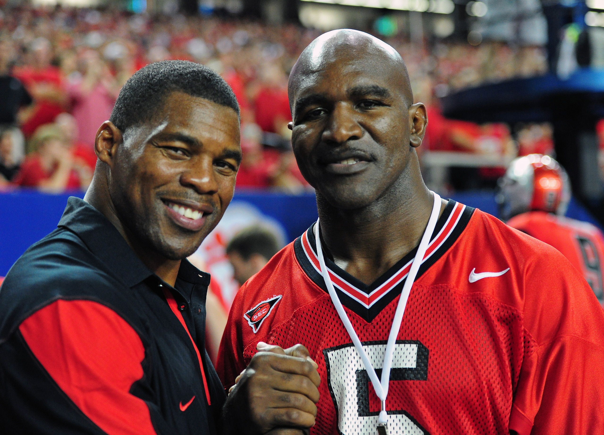 ATLANTA - SEPTEMBER 3: Former Georgia Bulldogs player Herschel Walker (L) poses for a photo with boxer Evander Holyfield during the game against the Boise State Broncos during the Chick-Fil-A Kickoff Game at the Georgia Dome on September 3, 2011 in Atlant