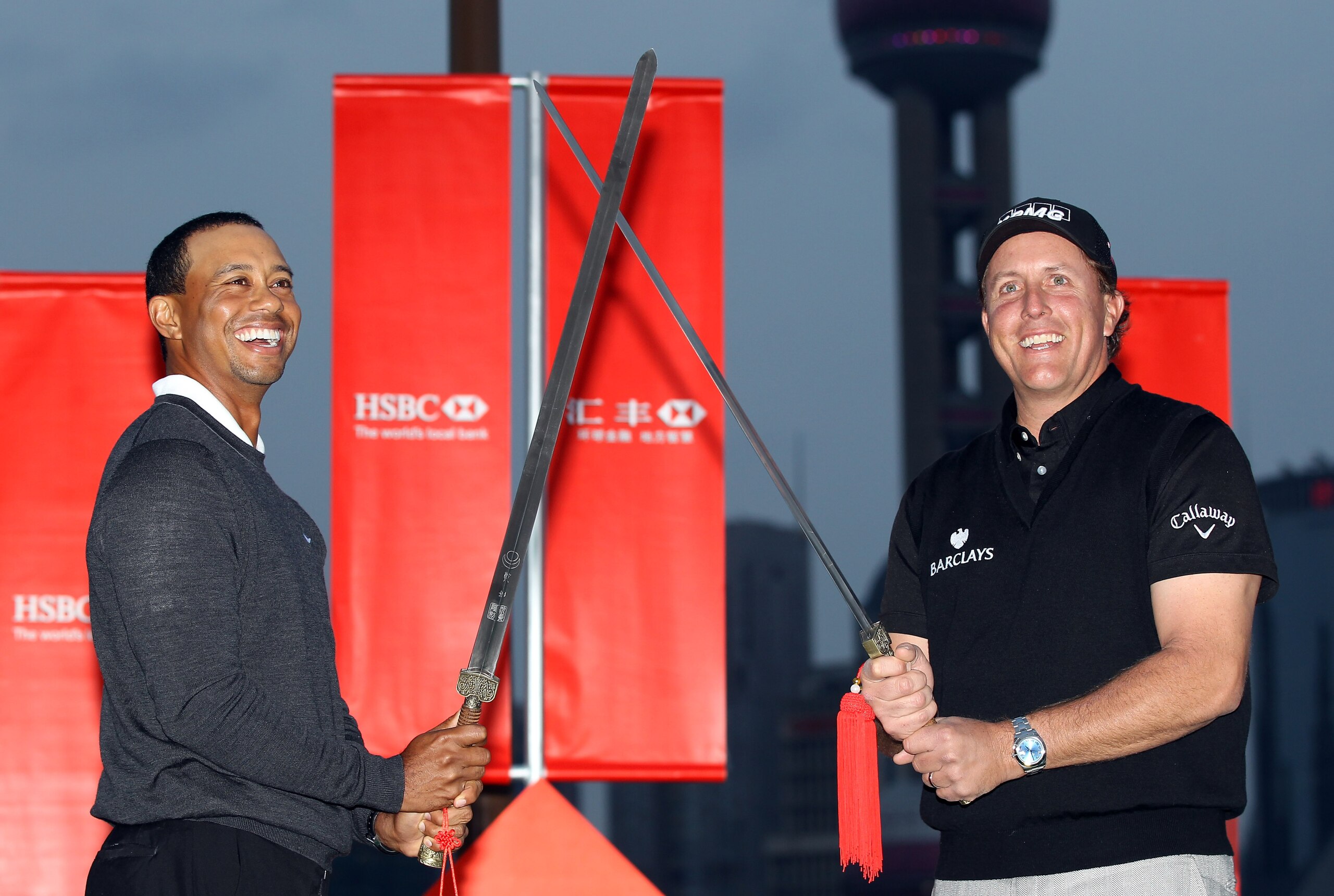 SHANGHAI, CHINA - NOVEMBER 02:  Tiger Woods of the USA (L) and Phil Mickelson of the USA cross swords during the 2010 WGC-HSBC Champions Photocall at The Peninsula hotel on The Bund, Shanghai on November 2, 2010 in Shanghai, China.  (Photo by Ross Kinnair