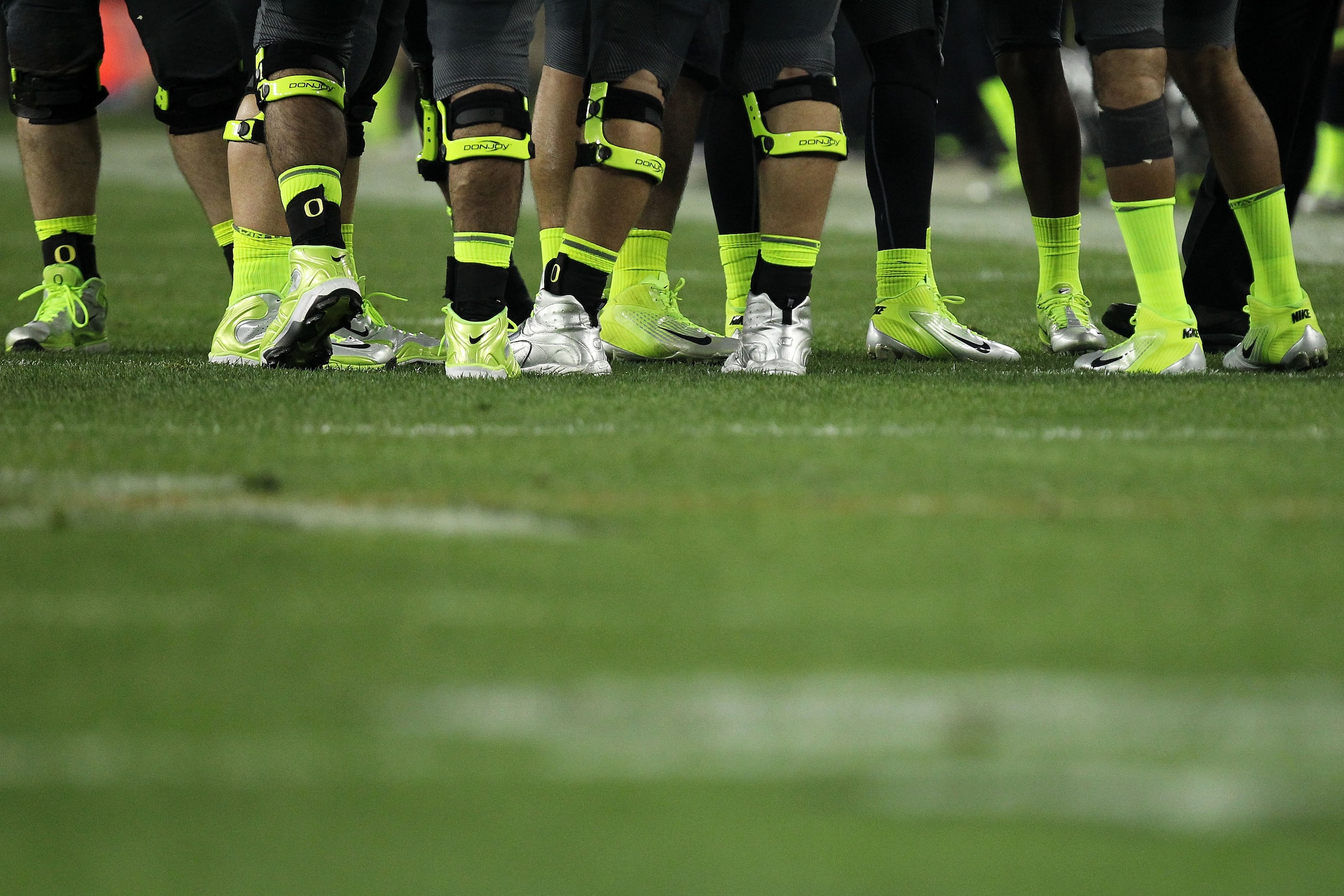 GLENDALE, AZ - JANUARY 10:  Oregon Ducks players wear green socks and shoes as they play the Auburn Tigers during the Tostitos BCS National Championship Game at University of Phoenix Stadium on January 10, 2011 in Glendale, Arizona.  (Photo by Ronald Mart