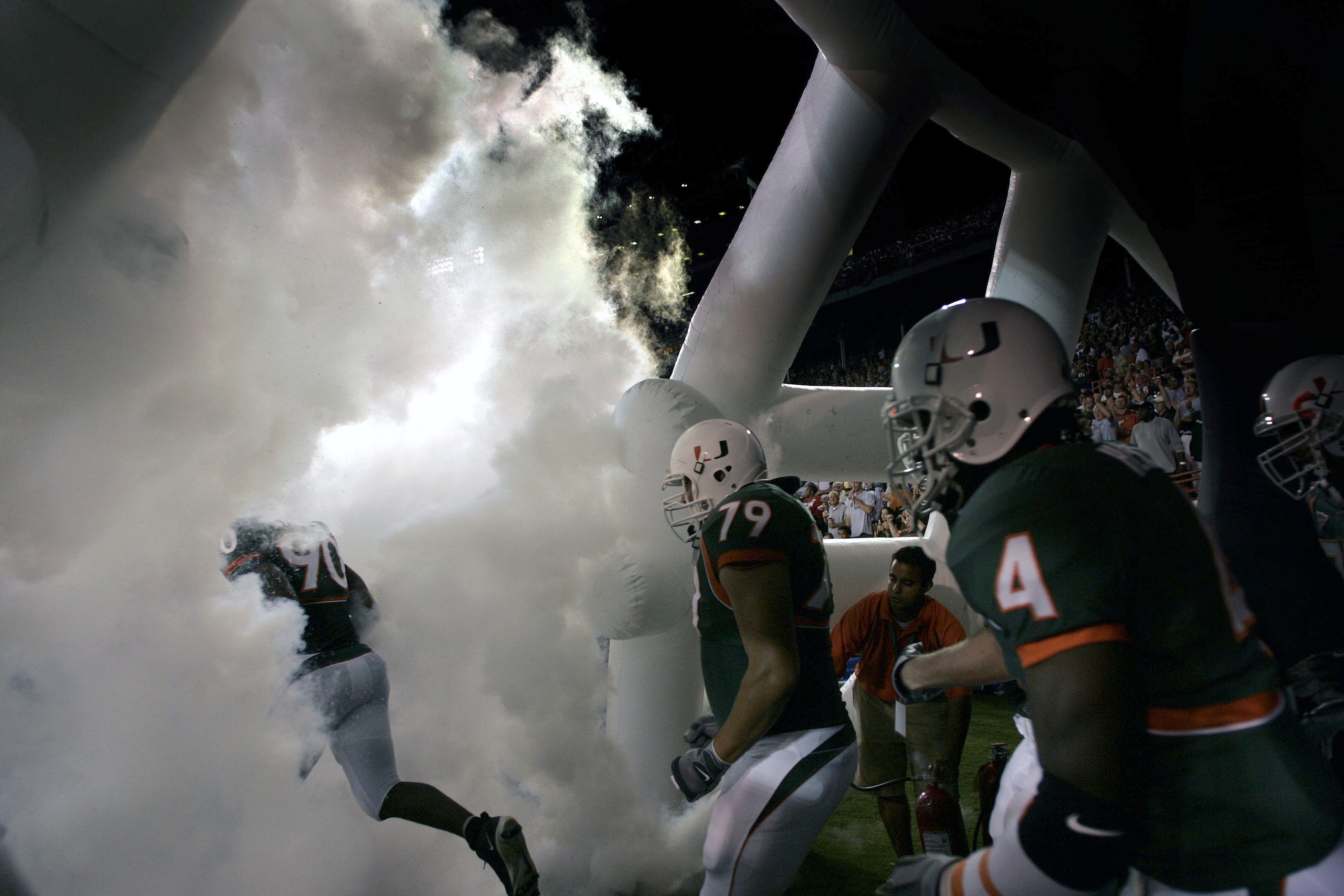MIAMI - OCTOBER 14: University of Miami football players run through smoke before the start of their game against the University of Louisville on October 14, 2004 at the Orange Bowl in Miami, Florida. (Photo by Eliot J. Schechter/Getty Images) MIAMI - OCTOBER 14: University of Miami football players run through smoke before the start of their game against the University of Louisville on October 14, 2004 at the Orange Bowl in Miami, Florida. (Photo by Eliot J. Schechter/Getty Images)