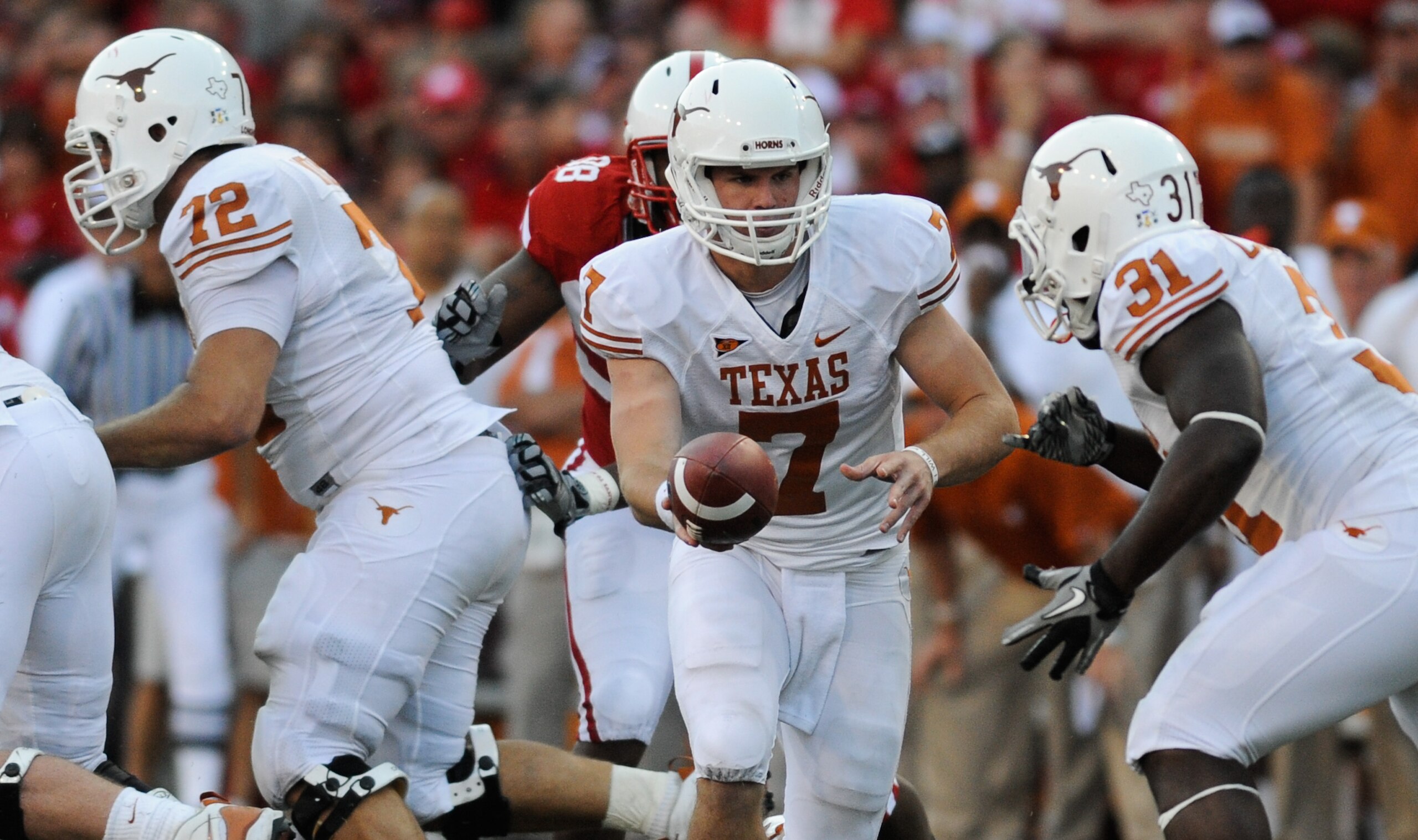 LINCOLN, NE - OCTOBER 16: Quarterback Garrett Gilbert #7 of the Texas Longhorns hand the ball to teammate running back Cody Johnson #31 during second half action of their game at Memorial Stadium on October 16, 2010 in Lincoln, Nebraska. Texas Defeated Ne