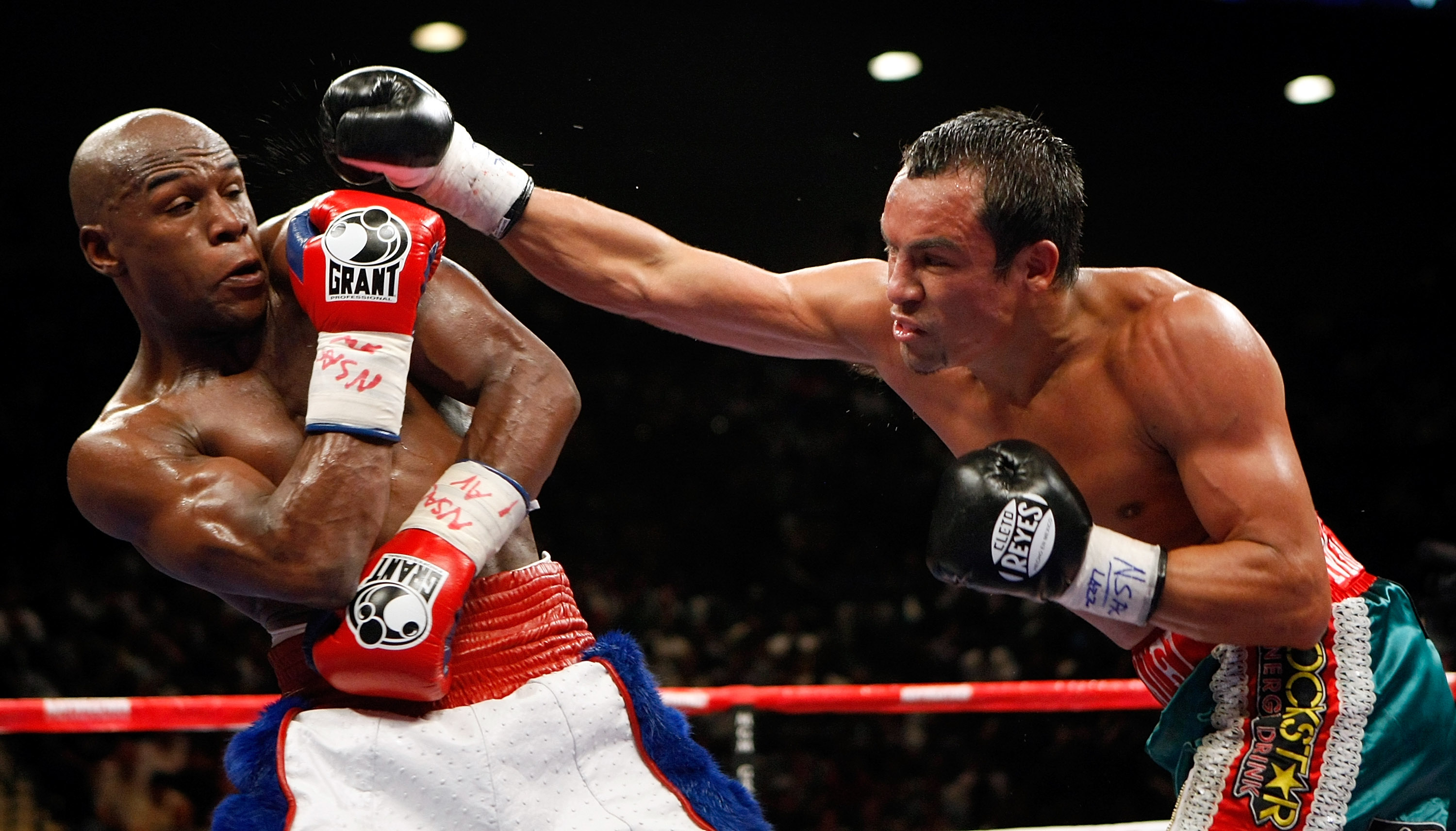 LAS VEGAS - SEPTEMBER 19:  Floyd Mayweather Jr. (L) dodges a punch from Juan Manuel Marquez in the fifth round of their fight at the MGM Grand Garden Arena September 19, 2009 in Las Vegas, Nevada. Mayweather won by unanimous decision.  (Photo by Ethan Mil