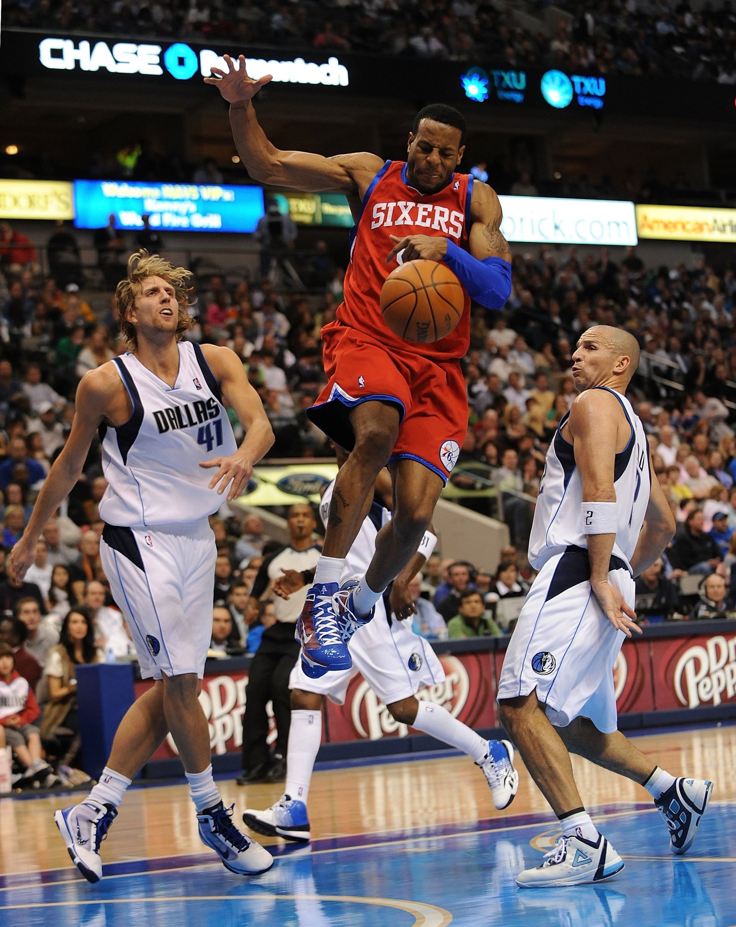 DALLAS - NOVEMBER 30:  Guard Andre Iguodala #9 of the Philadelphia 76ers rebounds against Dirk Nowitzki #41 and Jason Kidd #2 of the Dallas Mavericks on November 30, 2009 at American Airlines Center in Dallas, Texas.  NOTE TO USER: User expressly acknowle