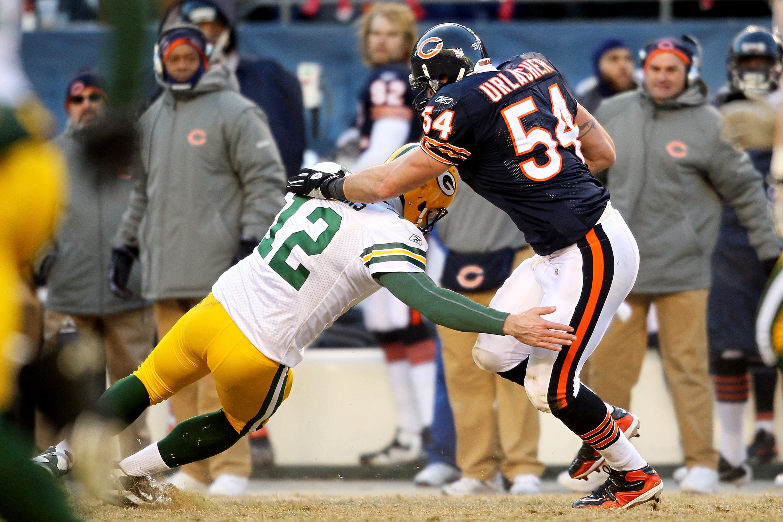 CHICAGO, IL - JANUARY 23:  Linebacker Brian Urlacher #54 of the Chicago Bears is tackled by quarterback Aaron Rodgers #12 of the Green Bay Packers after Urlacher runs an interception 39-yards in the third quarter in the NFC Championship Game at Soldier Fi