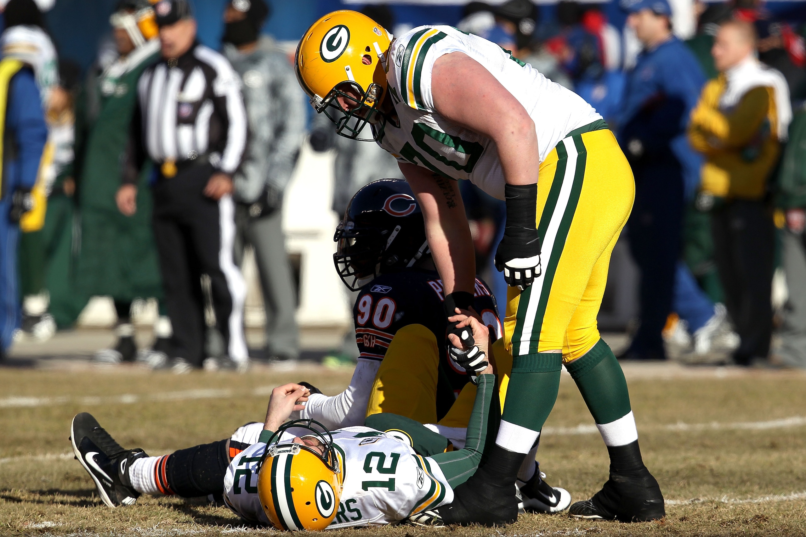CHICAGO, IL - JANUARY 23:  Quarterback Aaron Rodgers #12 of the Green Bay Packers lays on the turf after being knocked down by Julius Peppers #90 of the Chicago Bears in the first quarter in the NFC Championship Game at Soldier Field on January 23, 2011 i