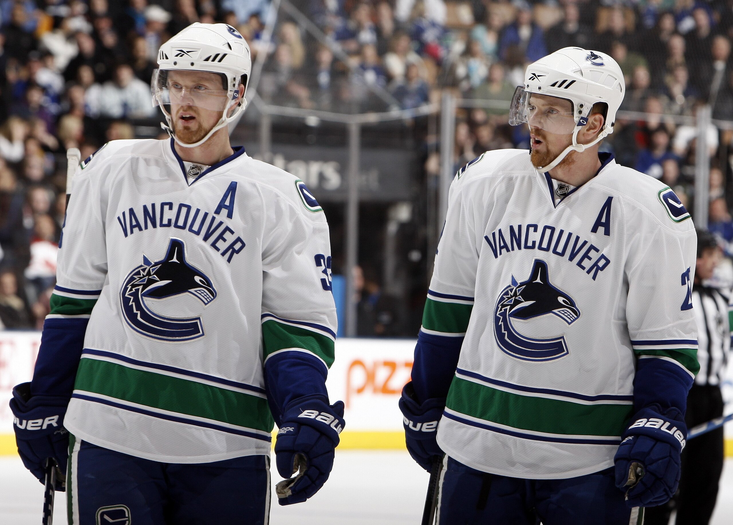 TORONTO - JANUARY 30: Daniel Sedin #22 and Henrik Sedin #33 of the Vancouver Canucks gets ready for a face-off during game action against the Toronto Maple Leafs January 30, 2010 at the Air Canada Centre in Toronto, Ontario, Canada. (Photo by Abelimages /