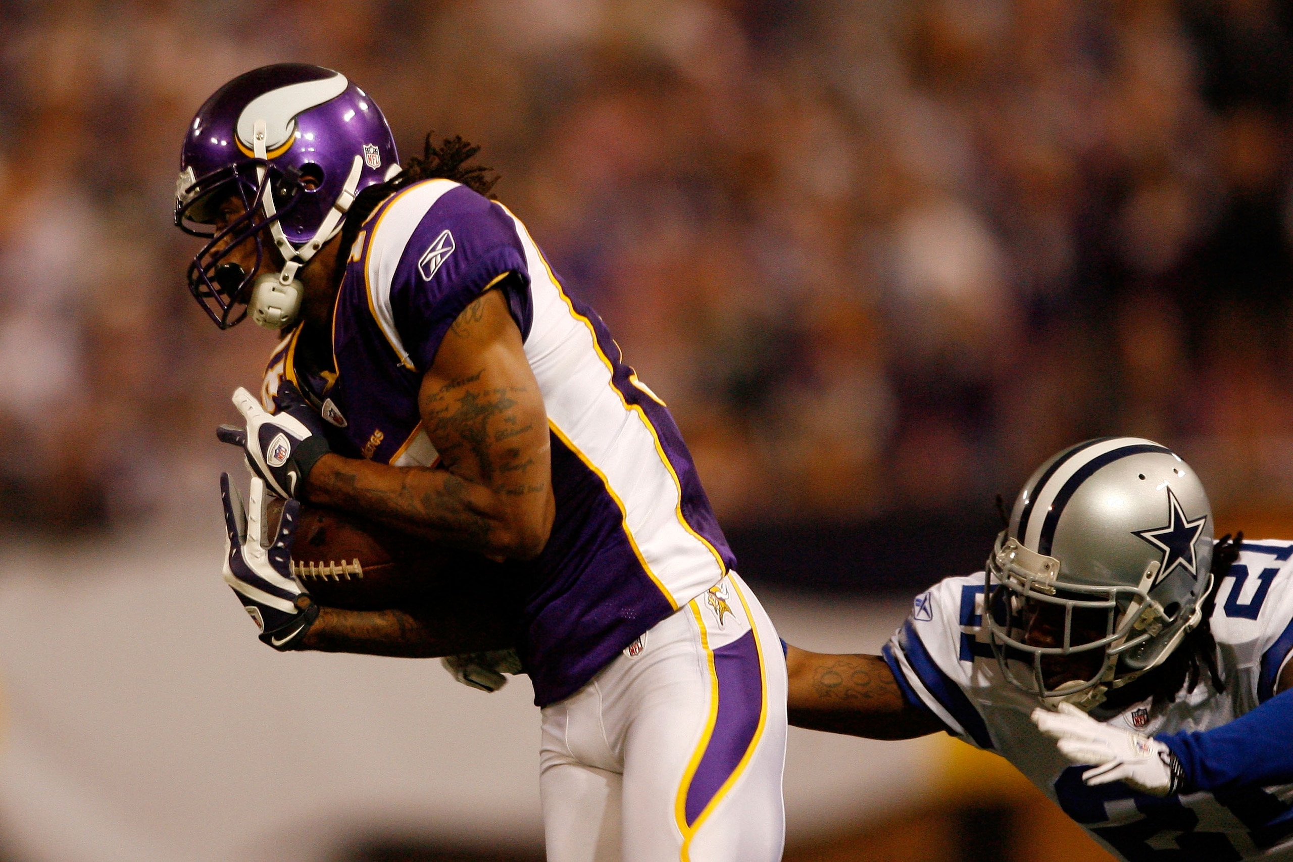 MINNEAPOLIS - JANUARY 17:  Wide receiver Sidney Rice #18 of the Minnesota Vikings breaks free from Mike Jenkins #21 of the Dallas Cowboys to score a touchdown during the fourth quarter of the NFC Divisional Playoff Game at Hubert H. Humphrey Metrodome on
