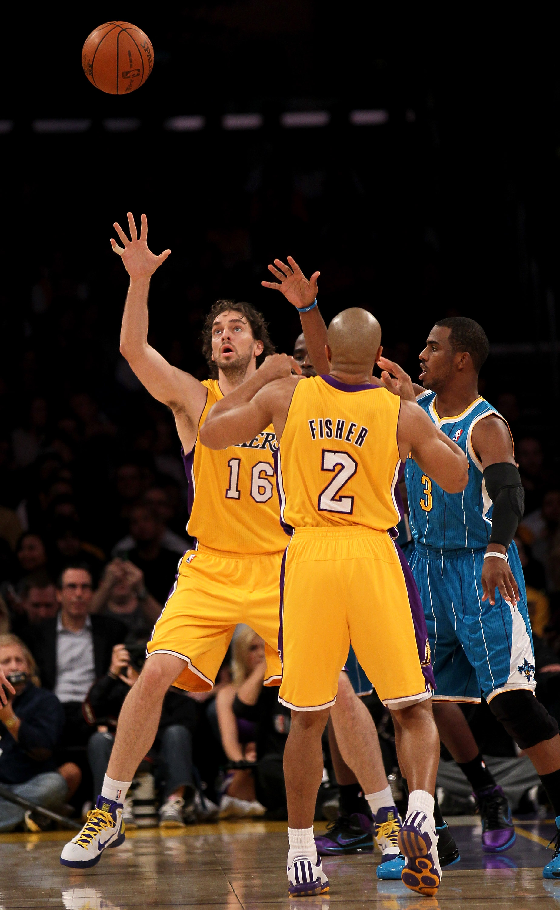 LOS ANGELES, CA - JANUARY 07:  Pau Gasol #16 of the Los Angeles Lakers reaches for a pass from Derek Fisher #16 as Chris Paul #3 of the New Orleans Hornets defends at Staples Center on January 7, 2011 in Los Angeles, California.  The Lakers won 101-97.  N