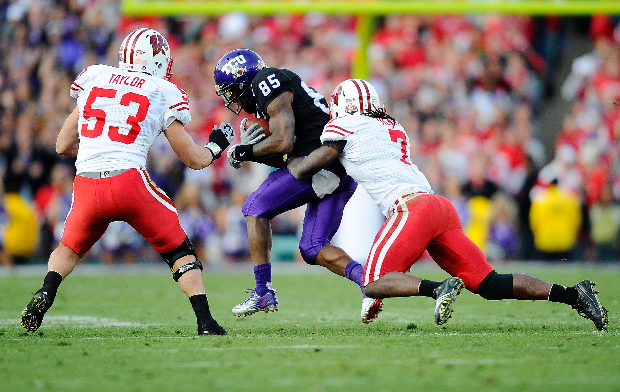 PASADENA, CA - JANUARY 01:  Wide receiver Jeremy Kerley #85 of the TCU Horned Frogs is tackled by defensive back Aaron Henry #7 of the Wisconsin Badgers in the 97th Rose Bowl game on January 1, 2011 in Pasadena, California.  (Photo by Kevork Djansezian/Ge