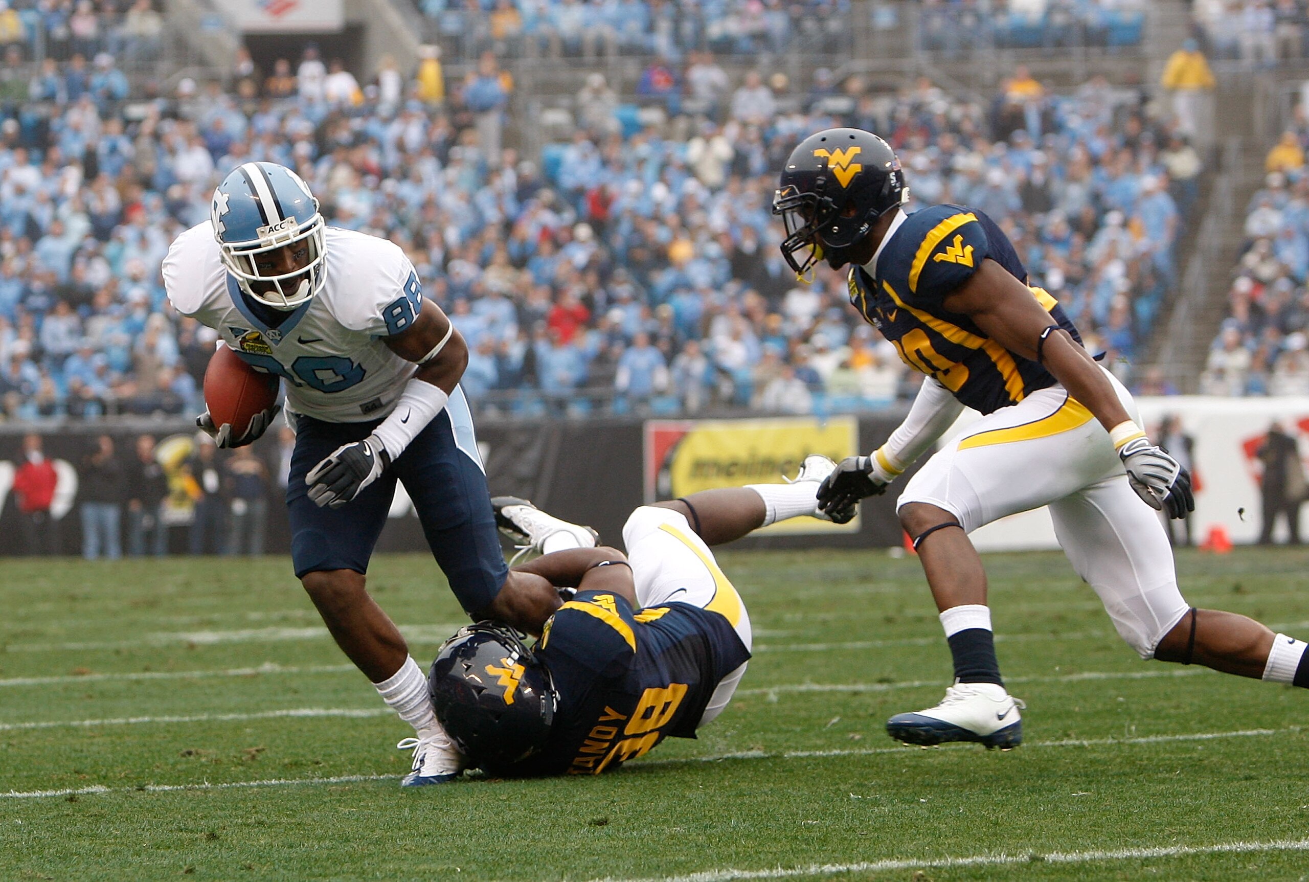 CHARLOTTE, NC - DECEMBER 27:  Hakeem Nicks #88 of the North Carolina Tar Heels breaks a tackle by Keith Tandy #38 of the West Virginia Mountaineers during the Meineke Car Care Bowl on December 27, 2008 at Bank of America Stadium in Charlotte, North Caroli