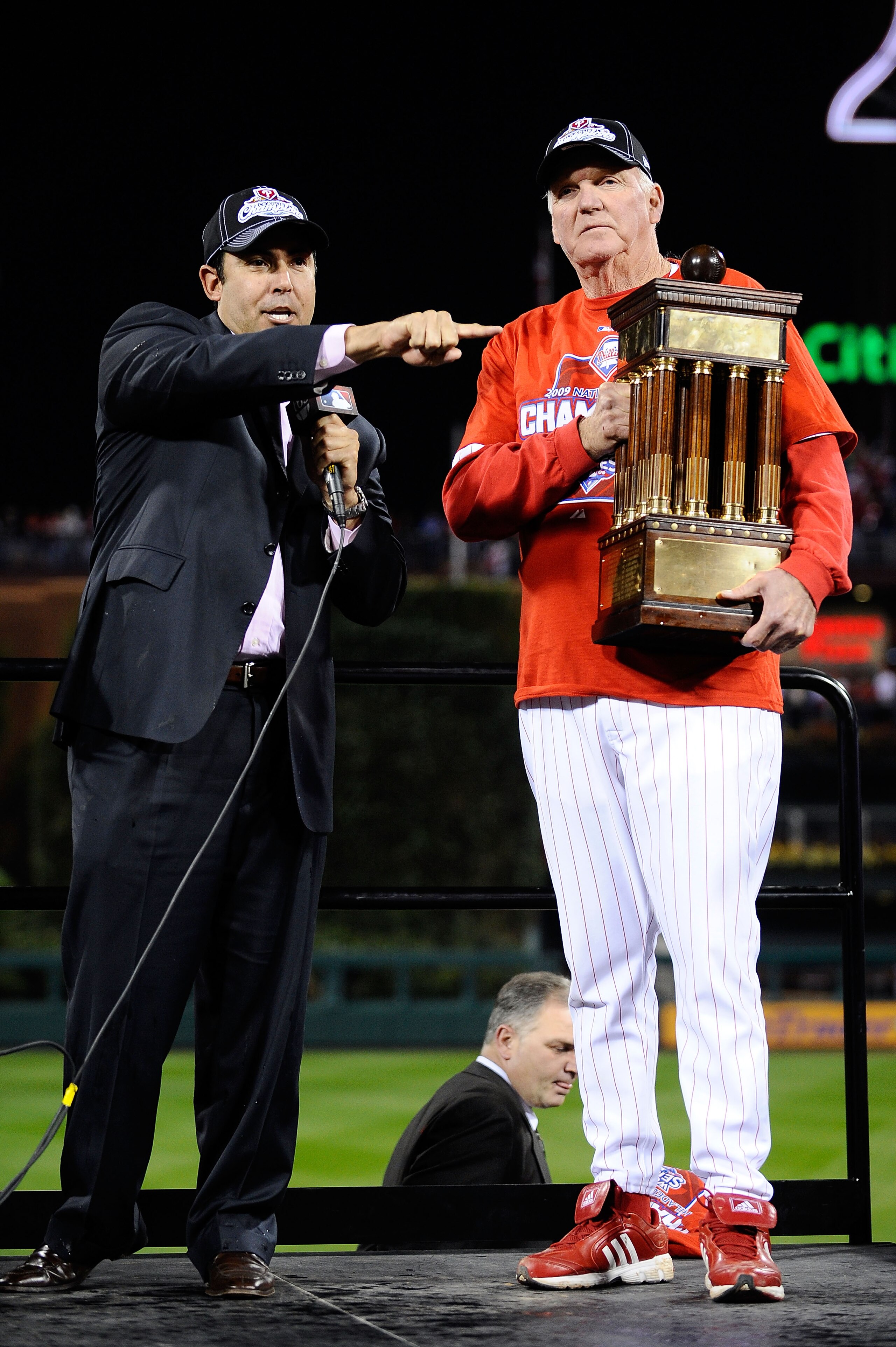 PHILADELPHIA - OCTOBER 21:  Manager Charlie Manuel of the Philadelphia Phillies halds the trophy with Phillies GM Ruben Amaro Jr. as they celebrate defeating the Los Angeles Dodgers 10-4 to advance to the World Series in Game Five of the NLCS during the 2