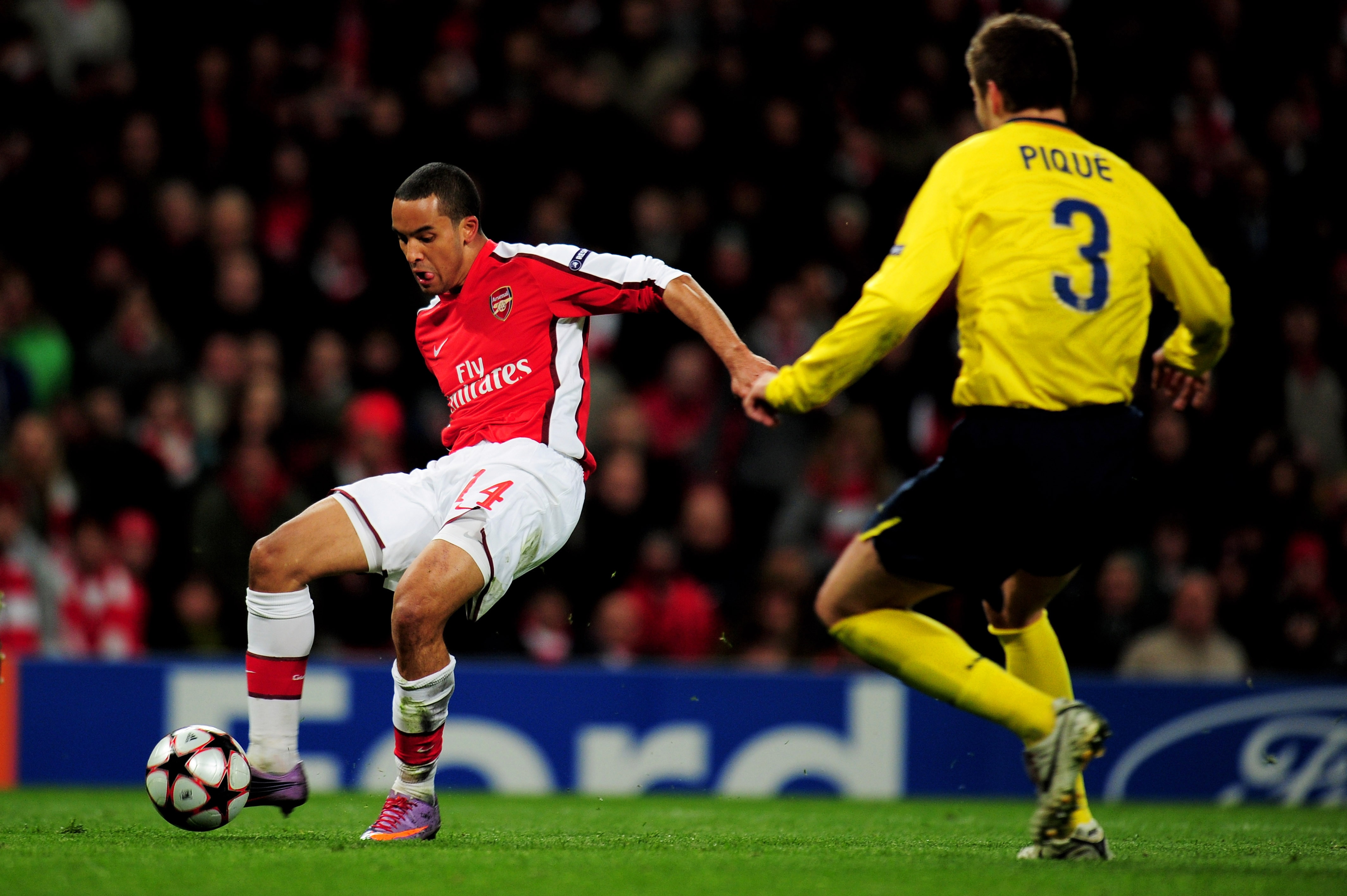 LONDON, ENGLAND - MARCH 31:  Theo Walcott of Arsenal shoots past Gerard Pique of Barcelona to score a goal during the UEFA Champions League quarter final first leg match between Arsenal and FC Barcelona at the Emirates Stadium on March 31, 2010 in London,