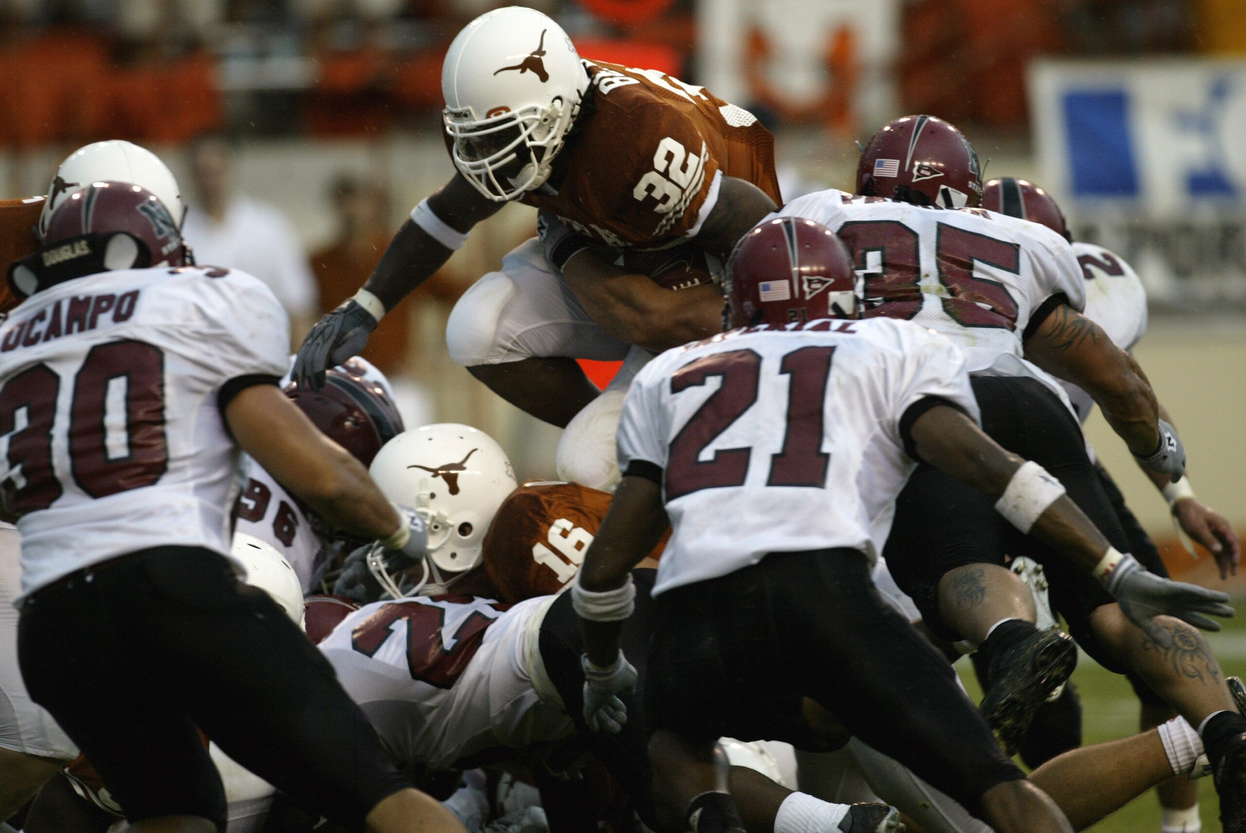 AUSTIN, TX - AUGUST 31:  Running back Cedric Benson #32 of the University of Texas at Austin Longhorns leaps over the New Mexico State University Aggies during the game Texas Memorial Stadium on August 31, 2003 in Austin, Texas. Texas defeated New Mexico 