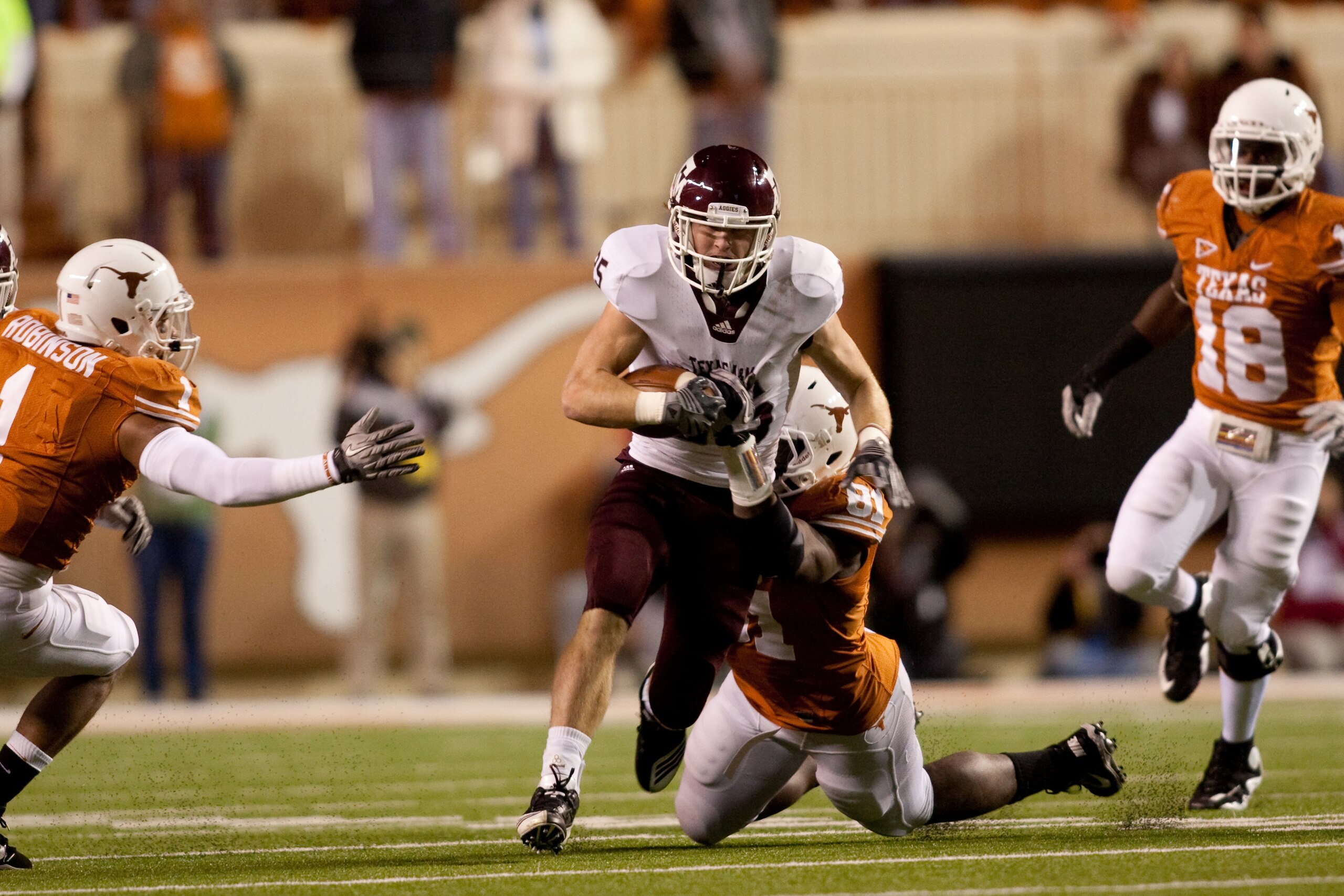 AUSTIN, TX - NOVEMBER 25: Running back Ryan Swope of Texas A&M #25 tries to break a tackle by University of Texas defensive end Sam Acho #81 during the first half at Darrell K. Royal-Texas Memorial Stadium on November 25, 2010 in Austin, Texas. (Photo by AUSTIN, TX - NOVEMBER 25: Running back Ryan Swope of Texas A&M #25 tries to break a tackle by University of Texas defensive end Sam Acho #81 during the first half at Darrell K. Royal-Texas Memorial Stadium on November 25, 2010 in Austin, Texas. (Photo by