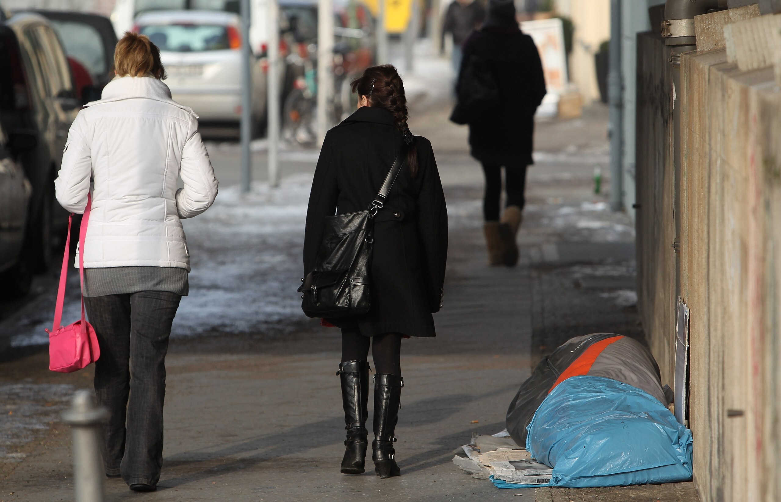 BERLIN - FEBRUARY 09:  People walk past a homeless man sleeping in a sleeping bag in subzero temperatures on February 9, 2010 in Berlin, Germany. Poverty in Germany has been on the rise in recent years.  (Photo by Sean Gallup/Getty Images)