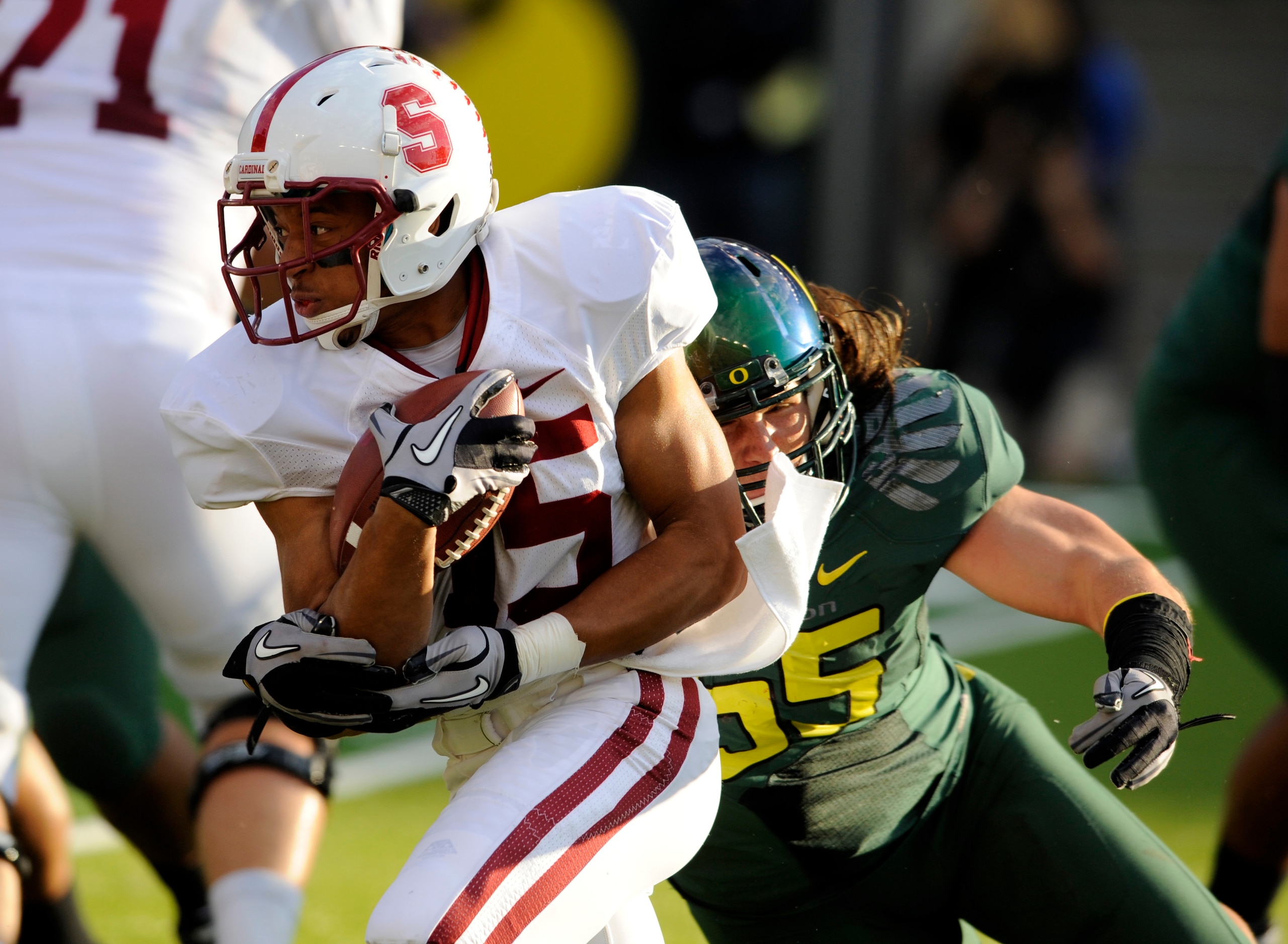 EUGENE, OR - OCTOBER 2: Running back Tyler Gaffney #25 of the Stanford Cardinal breaks through the line as he is tackled by linebacker Casey Matthews #55 of the Oregon Ducks in the first quarter of the game at Autzen Stadium on October 2, 2010 in Eugene,