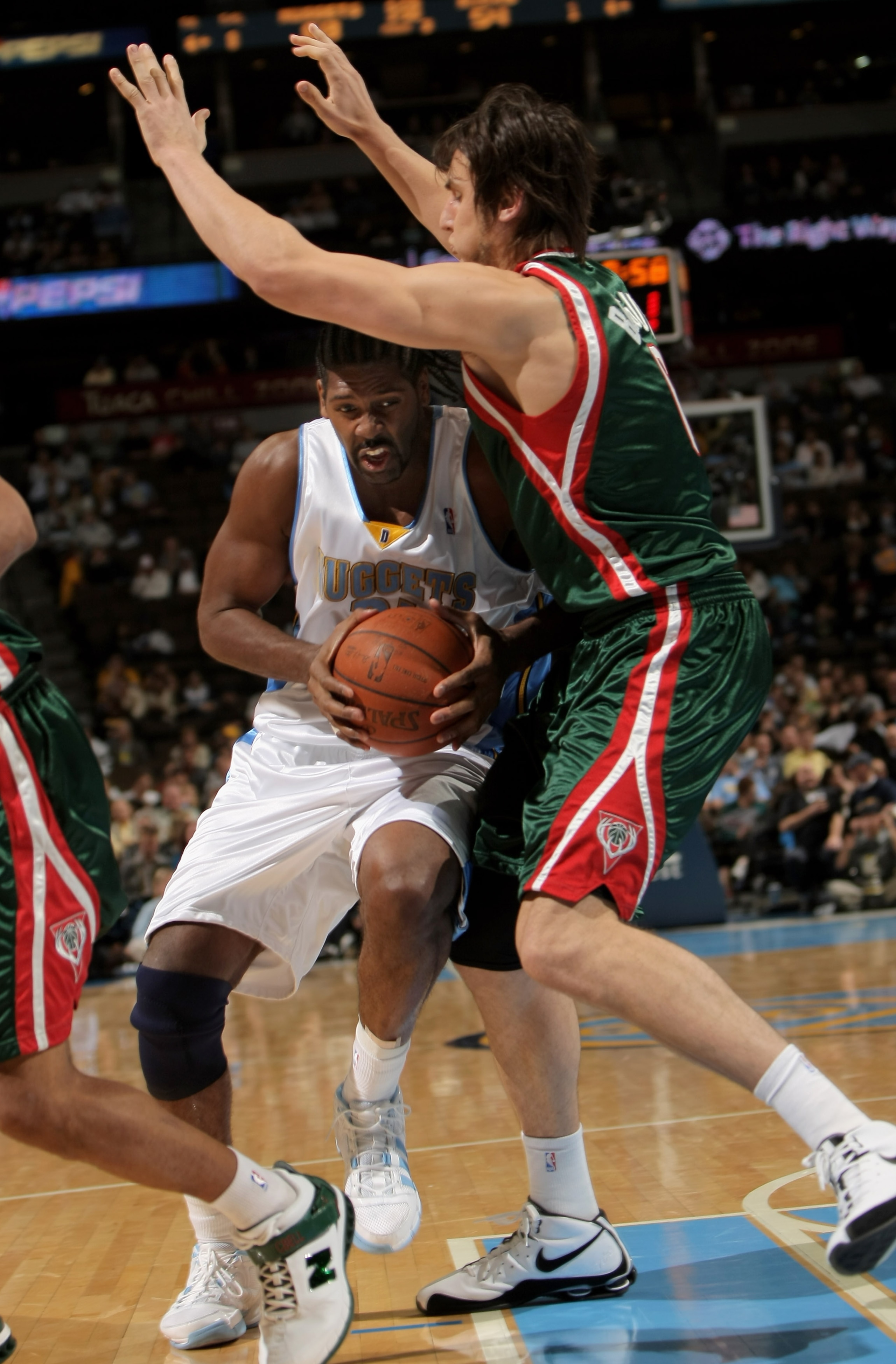 DENVER - NOVEMBER 18:  Nene #31 of the Denver Nuggets drives against the defense of Andrew Bogut #6 of the Milwaukee Bucks at the Pepsi Center on November 18, 2008 in Denver, Colorado. The Nuggets defeated the Bucks 114-105.  (Photo by Doug Pensinger/Gett