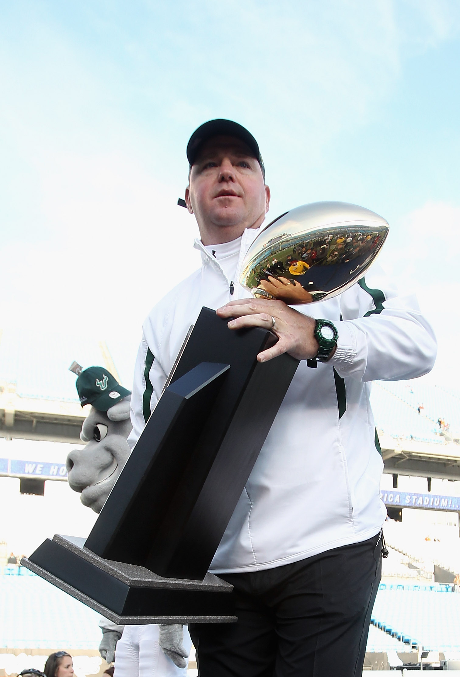 CHARLOTTE, NC - DECEMBER 31:  Head coach Skip Holtz of the USF Bulls stands with the trophy after a 31-26 victory over the Clemson Tigers at Bank of America Stadium on December 31, 2010 in Charlotte, North Carolina.  (Photo by Streeter Lecka/Getty Images)