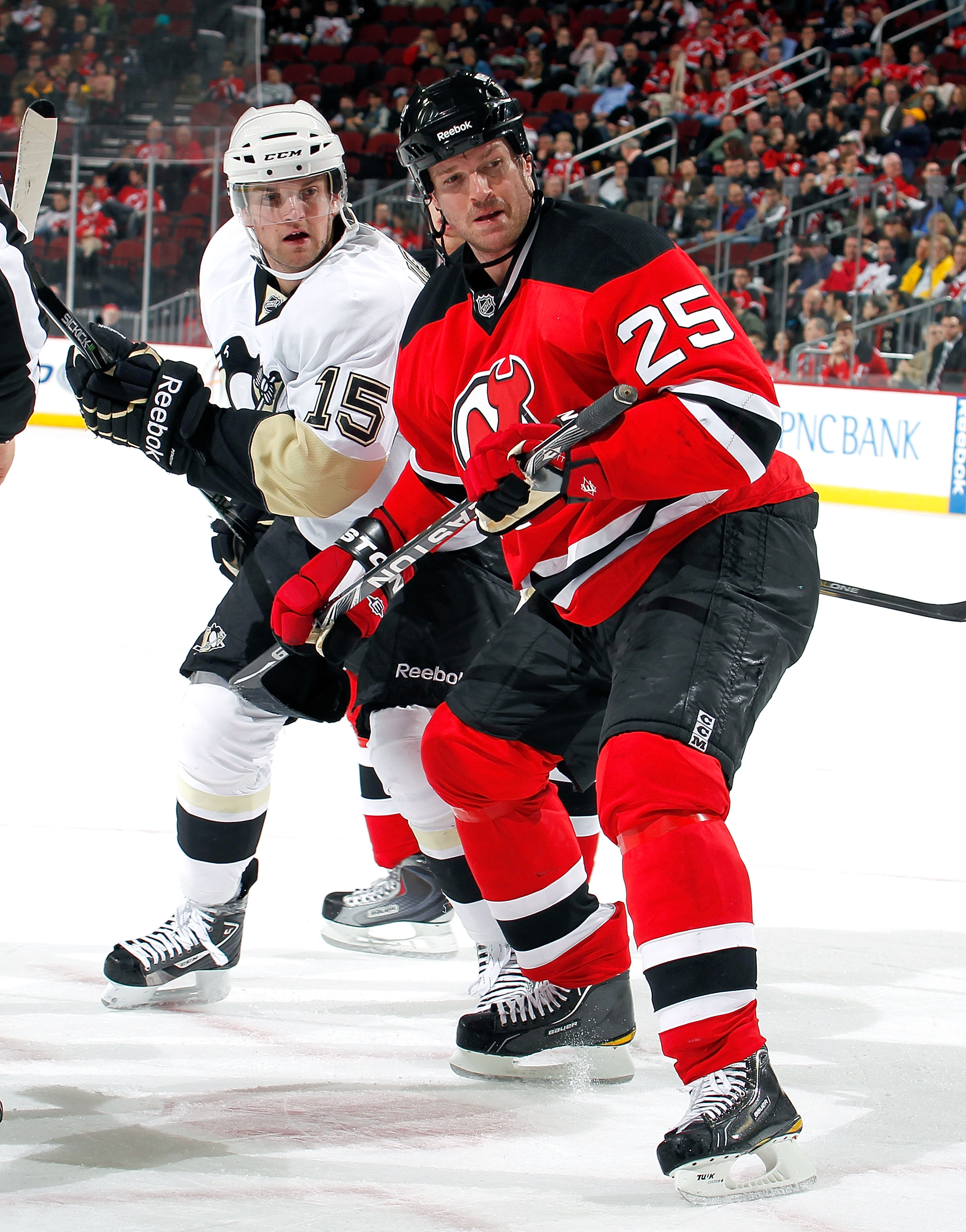 NEWARK, NJ - JANUARY 20:  Dustin Jeffrey #15 of the Pittsburgh Penguins and Jason Arnott #25 of the New Jersey Devils turn toward puck in an NHL hockey game at the Prudential Center on January 20, 2011 in Newark, New Jersey.  (Photo by Paul Bereswill/Gett