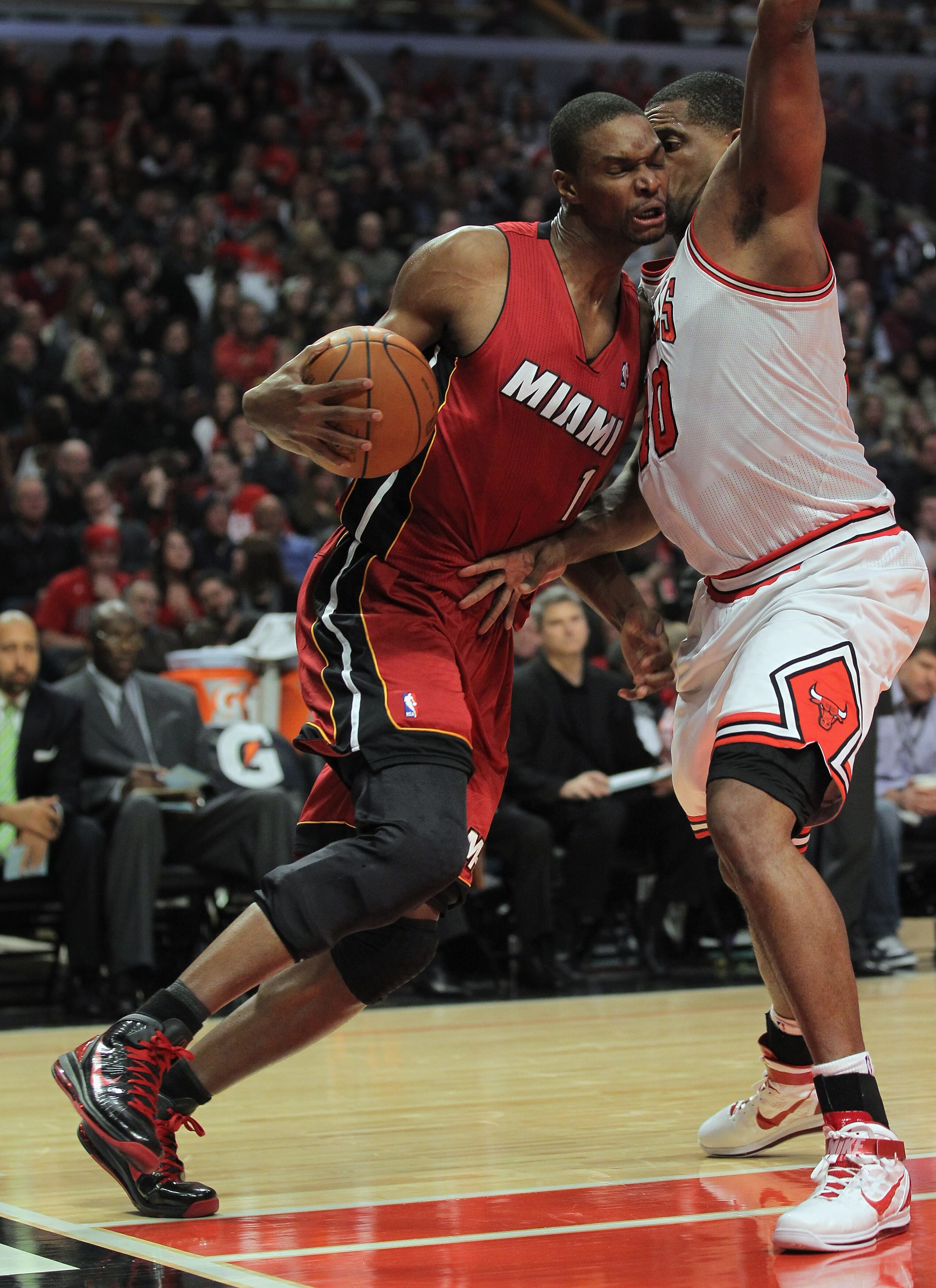 CHICAGO, IL - JANUARY 15:  Chris Bosh #1 of the Miami Heat is fouled by Kurt Thomas #40 of the Chicago Bulls at the United Center on January 15, 2011 in Chicago, Illinois. The Bulls defeated the Heat 99-96. NOTE TO USER: User expressly acknowledges and ag
