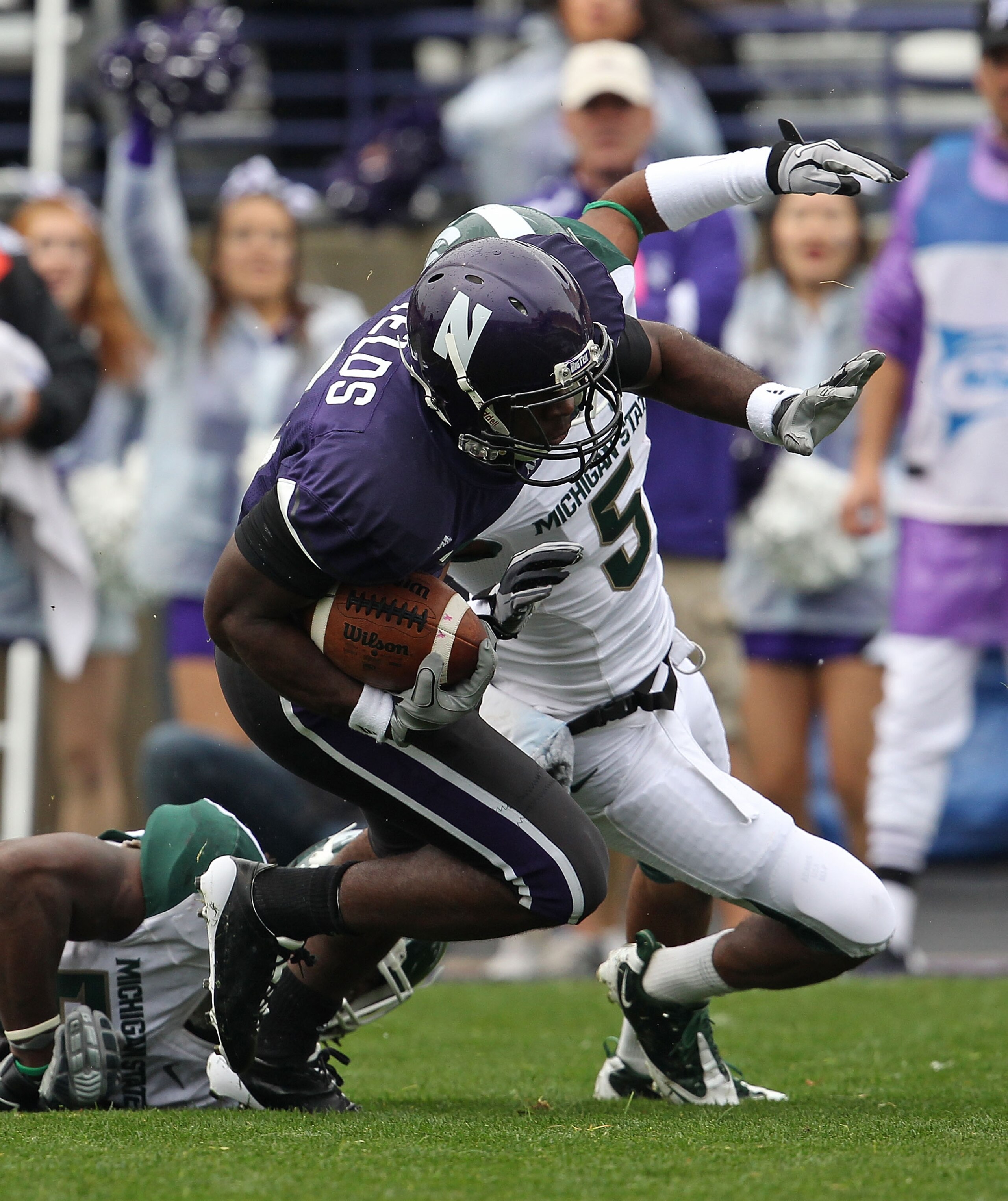 EVANSTON, IL - OCTOBER 23: Demetrius Fields #8 of the Northwestern Wildcats tries to avoid Johnny Adams #5 of the Michigan State Spartans at Ryan Field on October 23, 2010 in Evanston, Illinois. Michigan State defeated Northwestern 35-27.  (Photo by Jonat