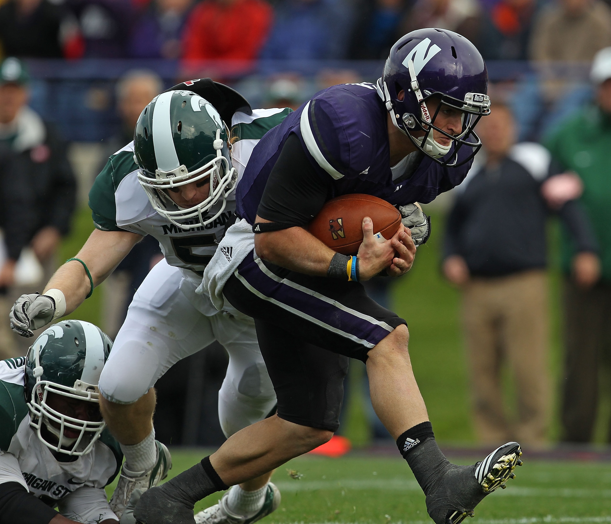 EVANSTON, IL - OCTOBER 23: Dan Persa #7 of the Northwestern Wildcats runs past Eric Gordon #43 of the Michigan State Spartans for a touchdown at Ryan Field on October 23, 2010 in Evanston, Illinois. Michigan State defeated Northwestern 35-27. (Photo by Jo