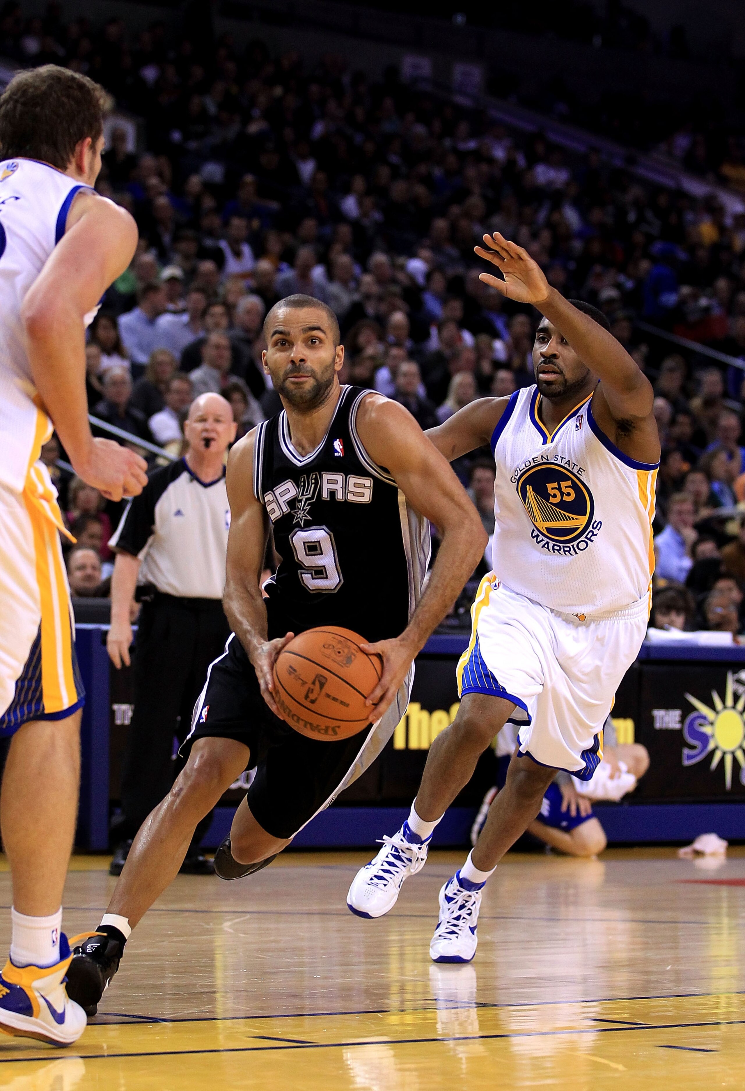 OAKLAND, CA - JANUARY 24:  Tony Parker #9 of the San Antonio Spurs drives on Reggie Williams #55 of the Golden State Warriors at Oracle Arena on January 24, 2011 in Oakland, California.  NOTE TO USER: User expressly acknowledges and agrees that, by downlo