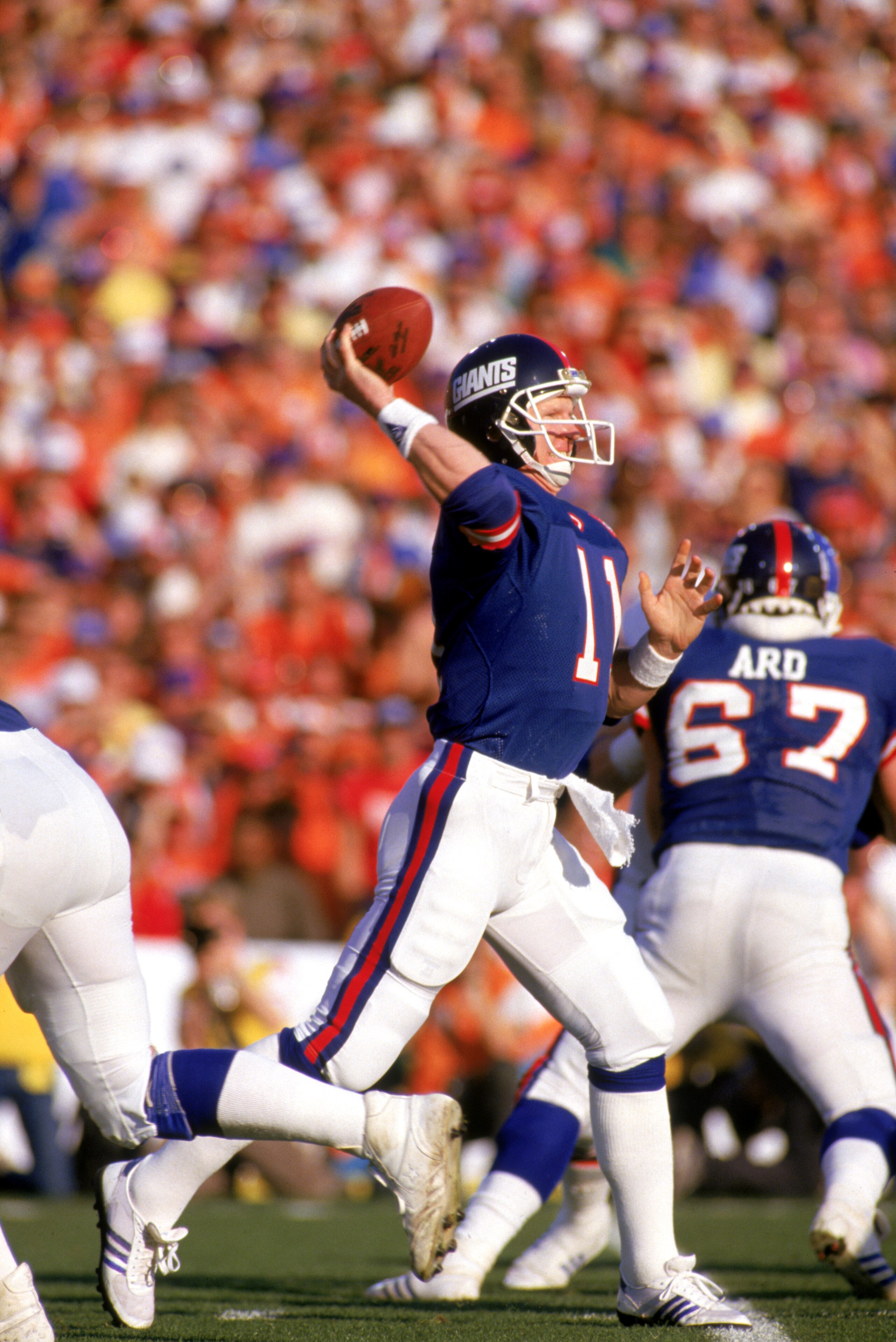 PASADENA, CA - JANUARY 25:  Quarterback Phil Simms #11 of the New York Giants passes against the Denver Broncos during Super Bowl XXI at the Rose Bowl on January 25, 1987 in Pasadena, California. The Giants defeated the Broncos 39-20. (Photo by George Ros