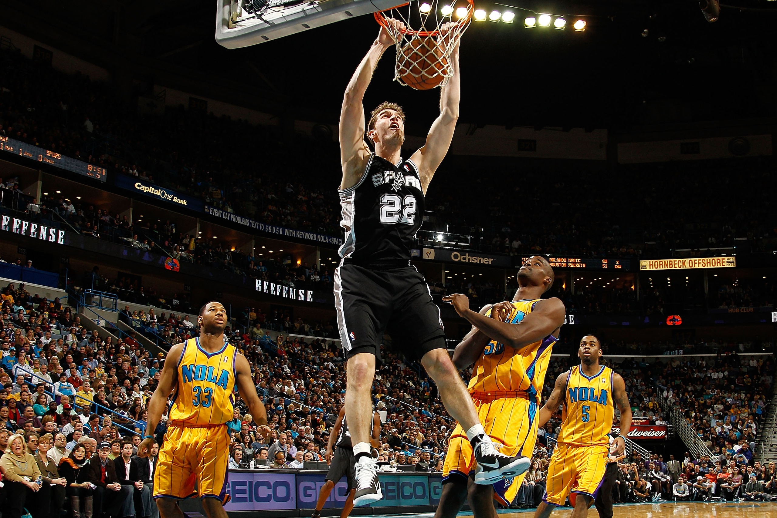 NEW ORLEANS, LA - JANUARY 22:  Tiago Splitter #22 of the San Antonio Spurs dunks the ball over Emeka Okafor #50 of the New Orleans Hornets at the New Orleans Arena on January 22, 2011 in New Orleans, Louisiana.  The Hornets defeated the Spurs 96-72.  NOTE