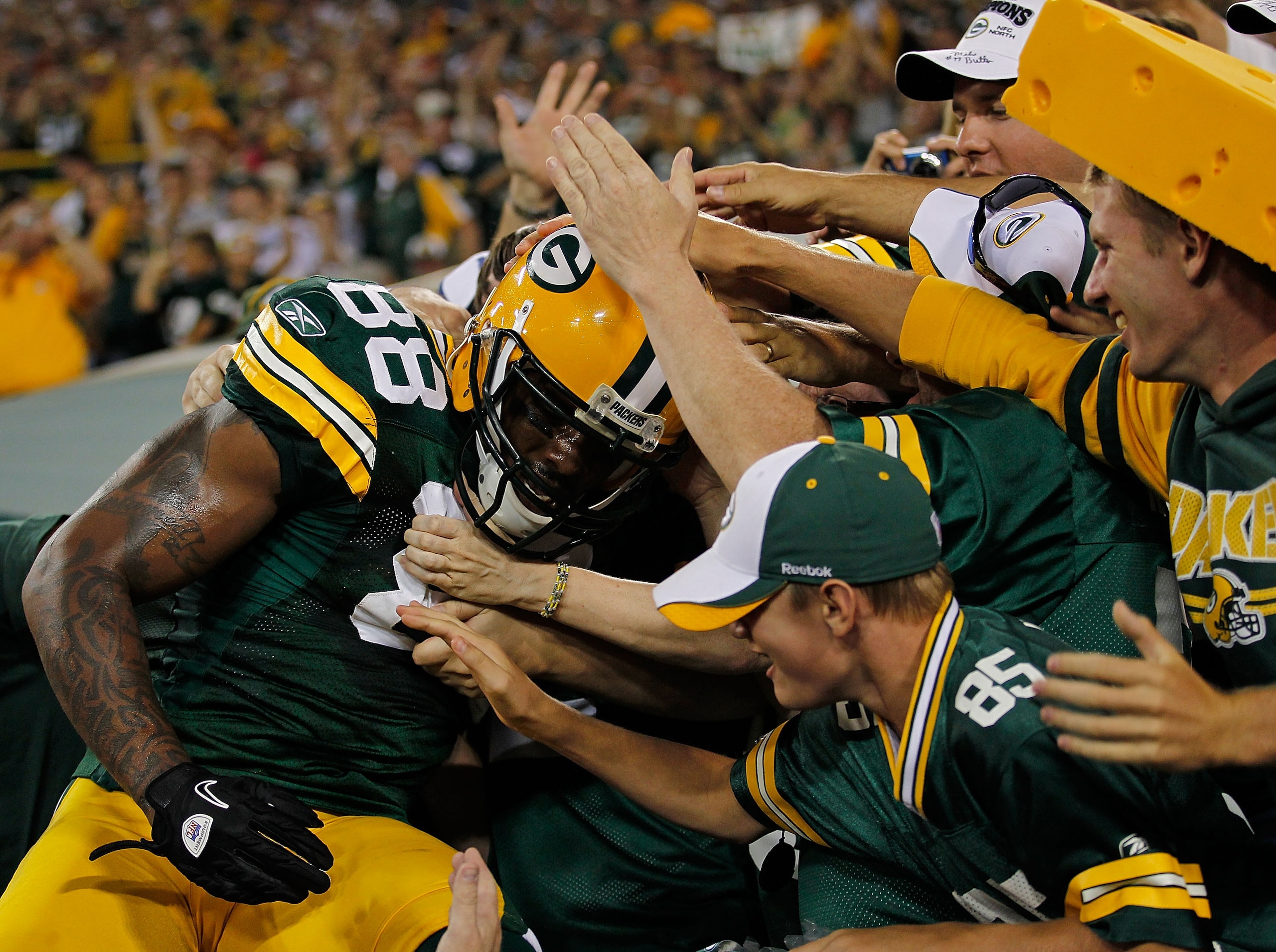 GREEN BAY, WI - AUGUST 26: Jermichael Finley #88 of the Green Bay Packers does a 'Lambeau Leap' into the stands after scoring a touchdown against the Indianapolis Colts during a preseason game at Lambeau Field on August 26, 2010 in Green Bay, Wisconsin. (