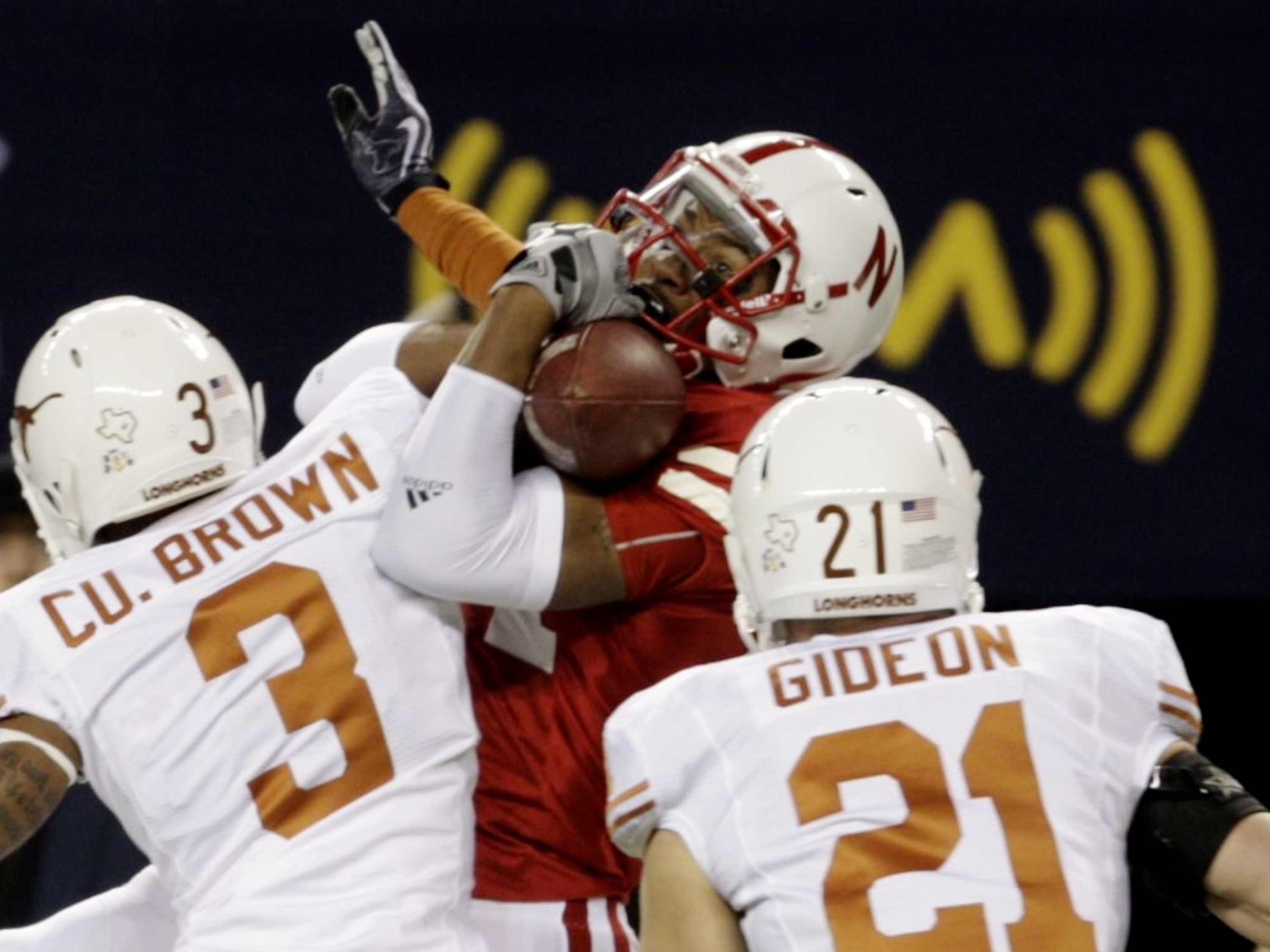 ARLINGTON, TX - DECEMBER 5:  Wide receiver Brandon Kinnie #84 of the Nebraska Cornhuskers cannot hold on for an incomplete pass in front of Curtis Brown #3 and Blake Gideon #21 of the Texas Longhorns in the first quarter of the game at Cowboys Stadium on 