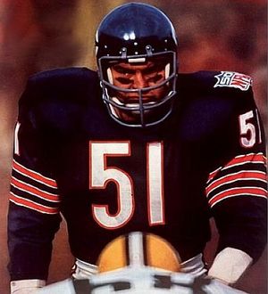 Dick Butkus Chicago Bears Autographed 8 x 10 Standing Photograph - Signed in Blue Ink