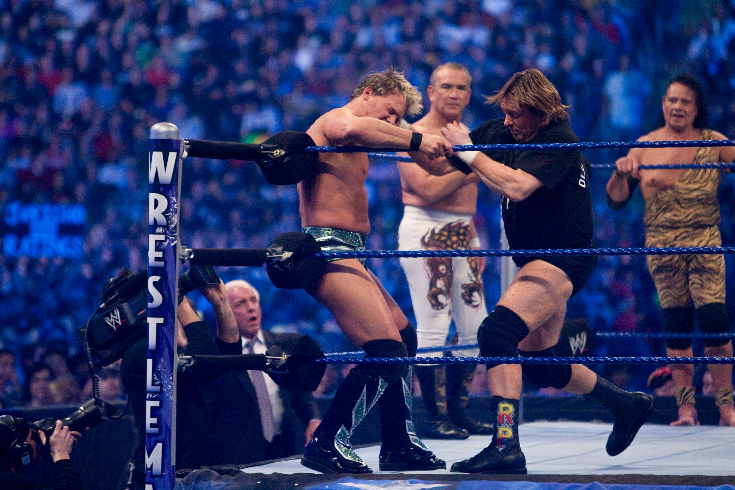 HOUSTON, TX - APRIL 5:  (L-R) Former professional wrestlers Ric Flair (seen outside the ring) looks on as WWE Superstar Chris Jericho gets pummeled on the ropes by 'Rowdy' Roddy Piper. Ricky 'The Dragon' Steamboat and Jimmy 'Superfly' Snuka look on during