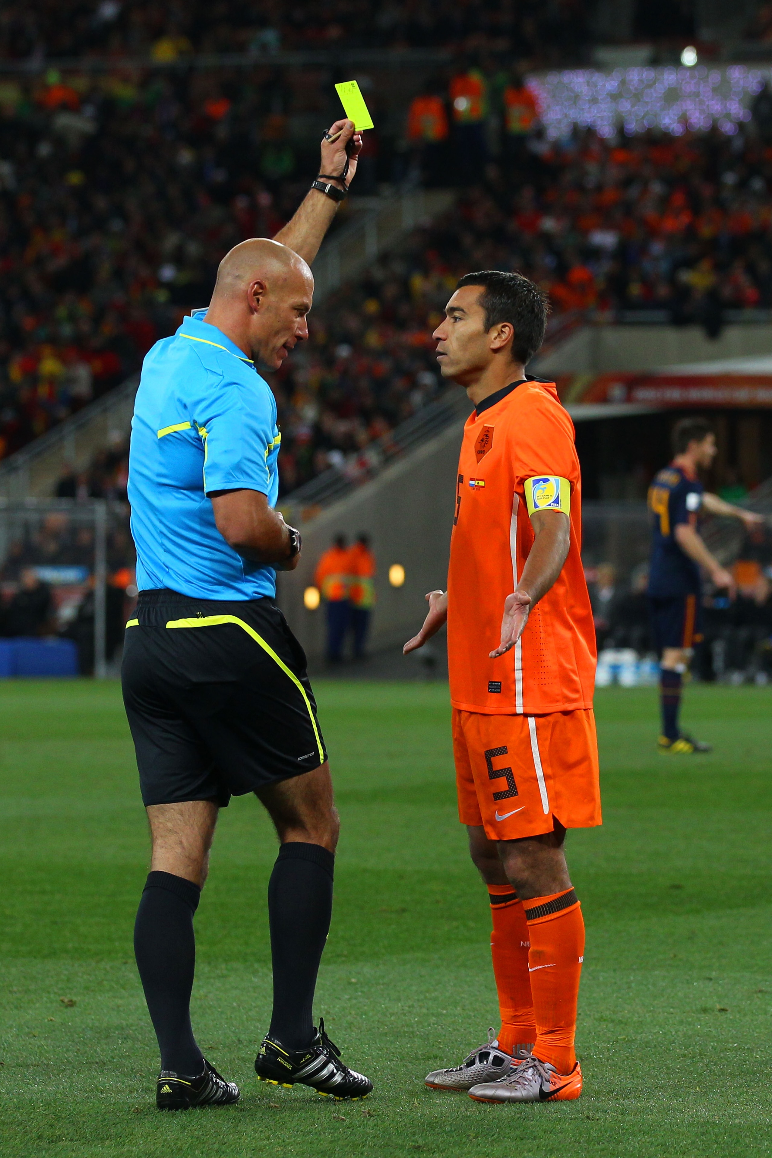 JOHANNESBURG, SOUTH AFRICA - JULY 11:  Referee Howard Webb issues Giovanni Van Bronckhorst of the Netherlands a yellow card during the 2010 FIFA World Cup South Africa Final match between Netherlands and Spain at Soccer City Stadium on July 11, 2010 in Jo