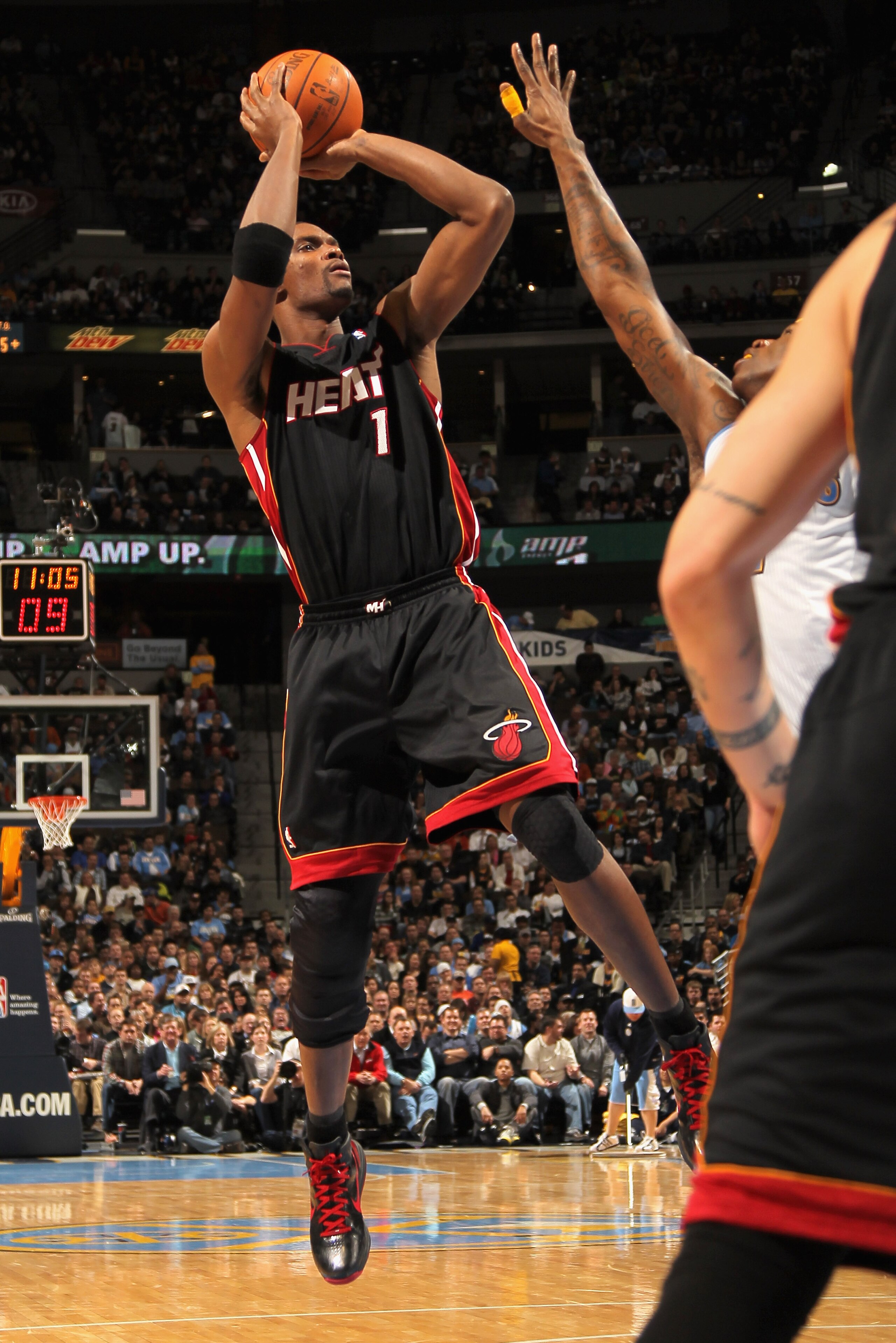 DENVER, CO - JANUARY 13:  Chris Bosh #1 of the Miami Heat takes a shot against the Denver Nuggets at the Pepsi Center on January 13, 2011 in Denver, Colorado. NOTE TO USER: User expressly acknowledges and agrees that, by downloading and or using this phot