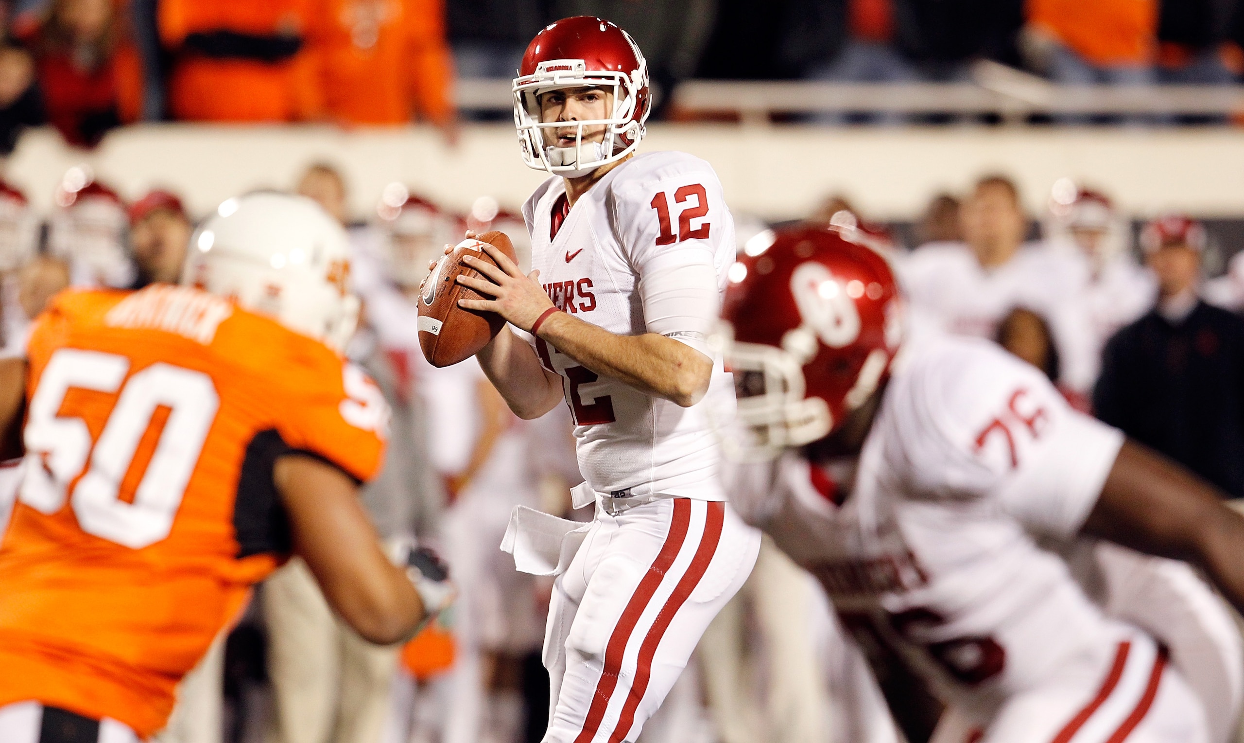 STILLWATER, OK - NOVEMBER 27:  Quarterback Landry Jones #12 of the Oklahoma Sooners looks for an open receiver against the Oklahoma State Cowboys at Boone Pickens Stadium on November 27, 2010 in Stillwater, Oklahoma.  (Photo by Tom Pennington/Getty Images