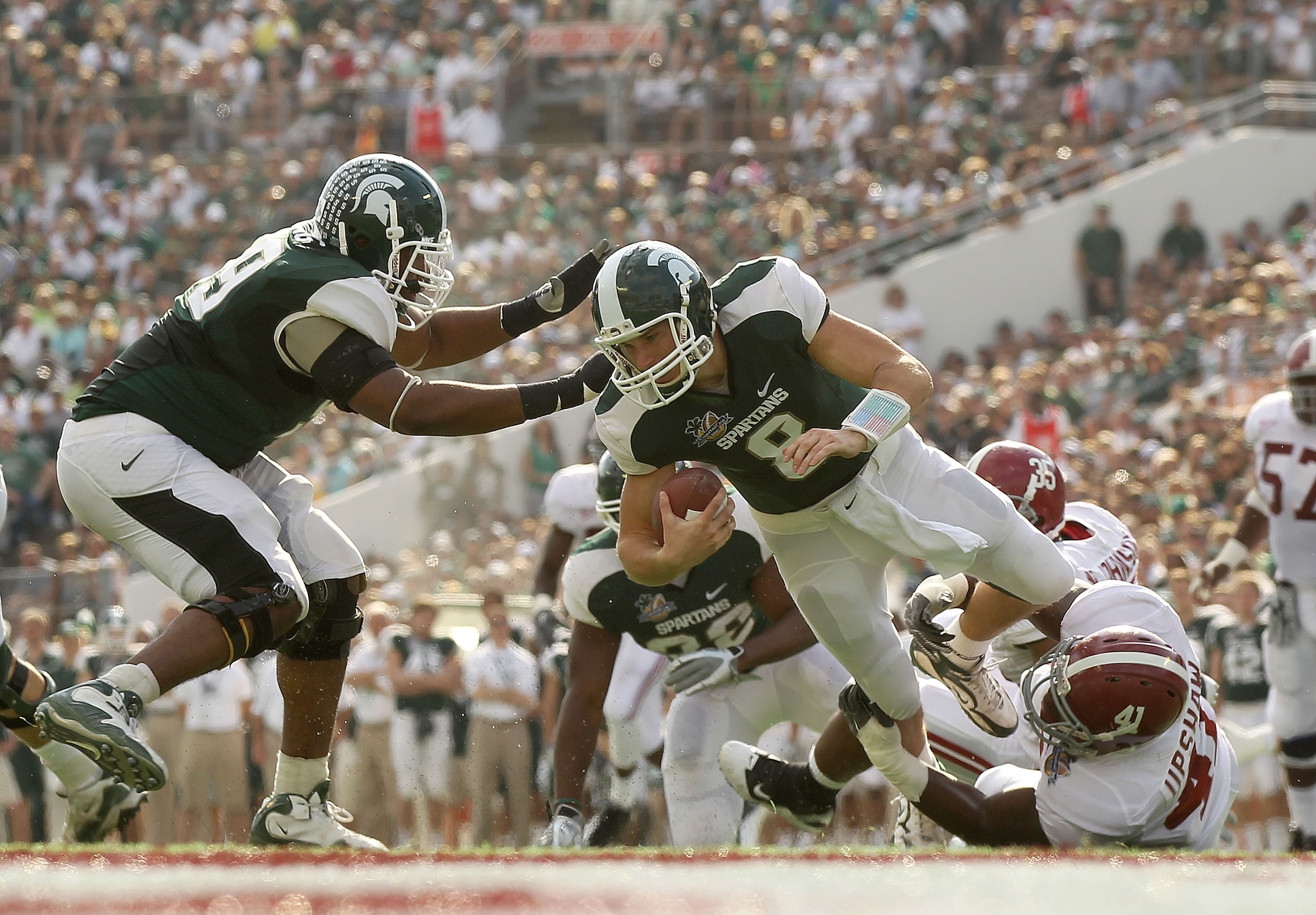 ORLANDO, FL - JANUARY 01:  Kirk Cousins #8  of the Michigan State Spartans is sacked by Courtney Upshaw #41 of the Alabama Crimson Tide during the Capitol One Bowl at the Florida Citrus Bowl on January 1, 2011 in Orlando, Florida.  (Photo by Mike Ehrmann/