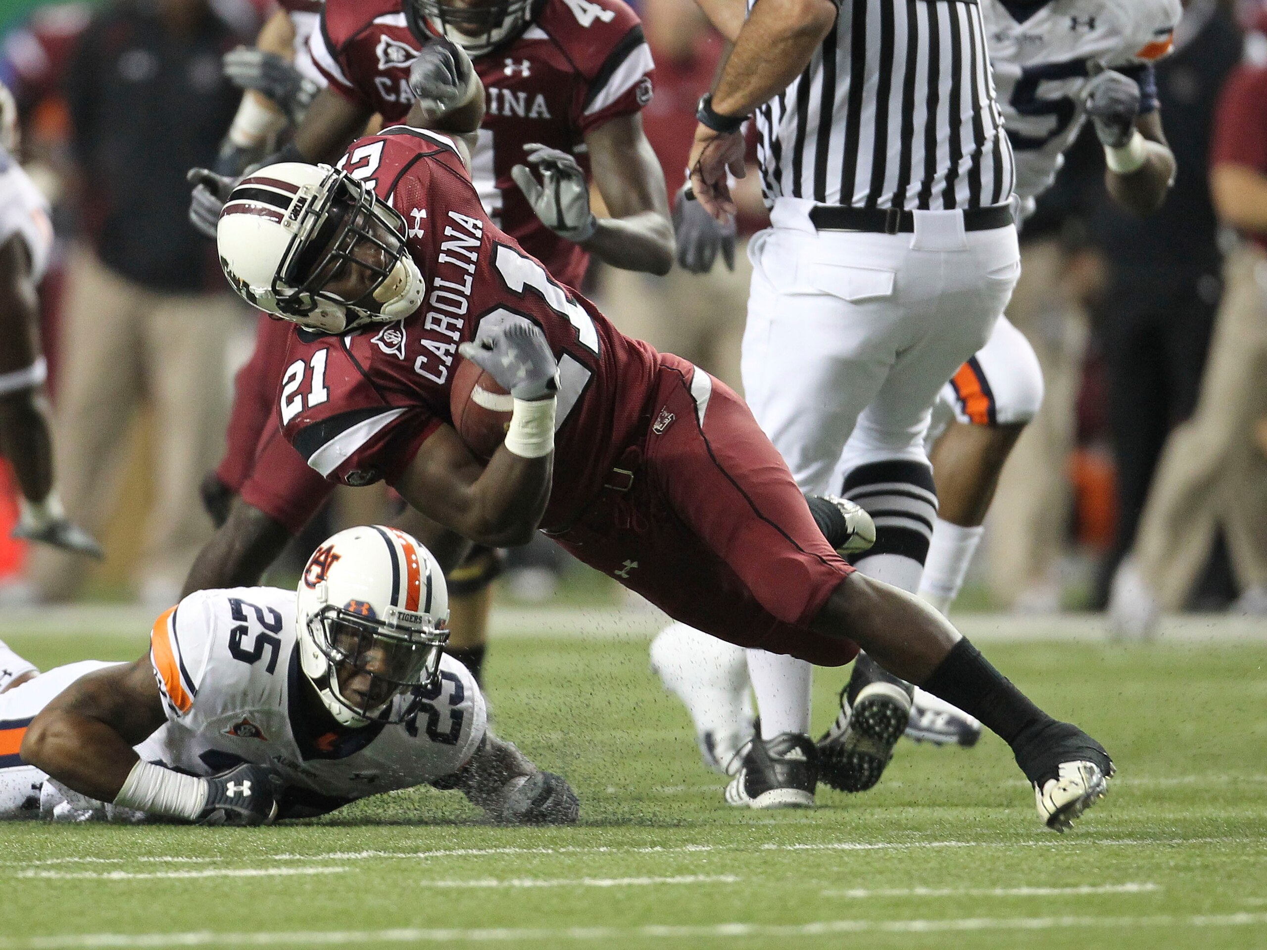 ATLANTA - DECEMBER 4:  Running back Marcus Lattimore #21 of the South Carolina Gamecocks is tackled by Daren Bates #25 of the Auburn Tigers during the 2010 SEC Championship at Georgia Dome on December 4, 2010 in Atlanta, Georgia. (Photo by Mike Zarrilli/G