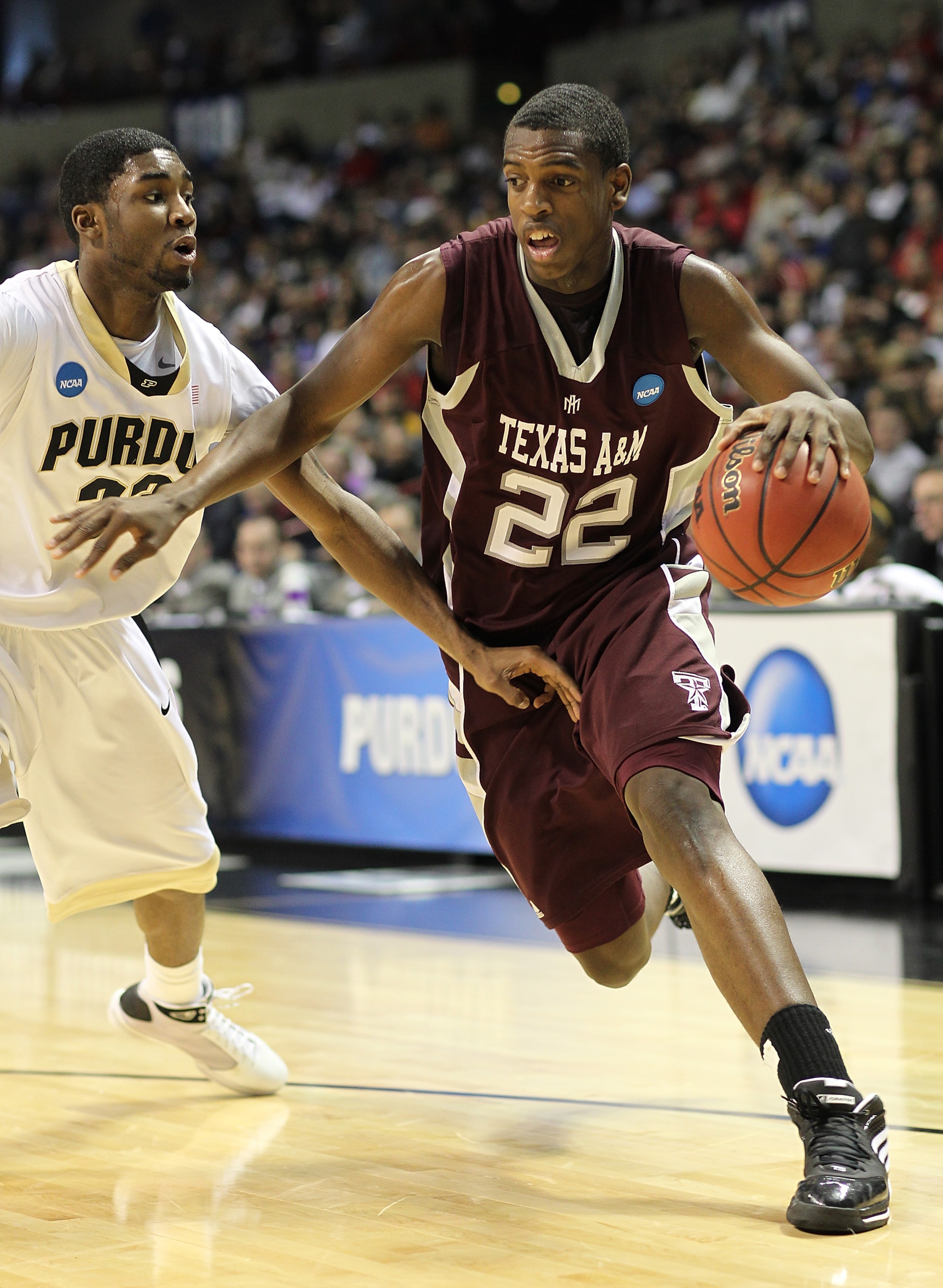 SPOKANE, WA - MARCH 21:  Khris Middleton #22 of the Texas A&M  Aggies drives against E'Twaun Moore #33 of the Purdue Boilermakers during the second round of the 2010 NCAA men's basketball tournament at the Spokane Arena on March 21, 2010 in Spokane, Washi