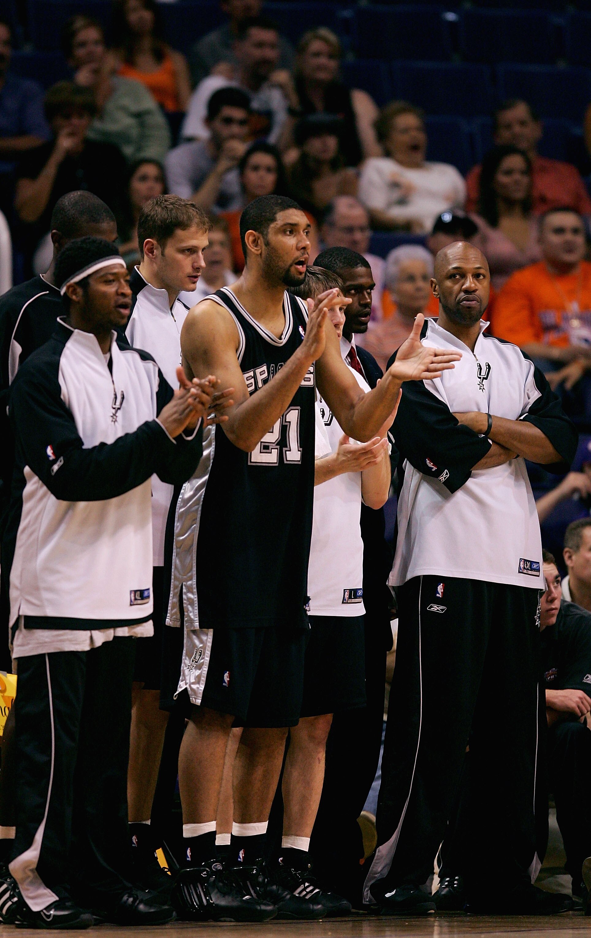 PHOENIX - MAY 22:  (L-R)Devin Brown #23, Tim Duncan #21 and Tony Massenburg #34 of the San Antonio Spurs cheer from the sidelines as their team leads the Phoenix Suns in Game one of the Western Conference Finals during the 2005 NBA Playoffs at America Wes