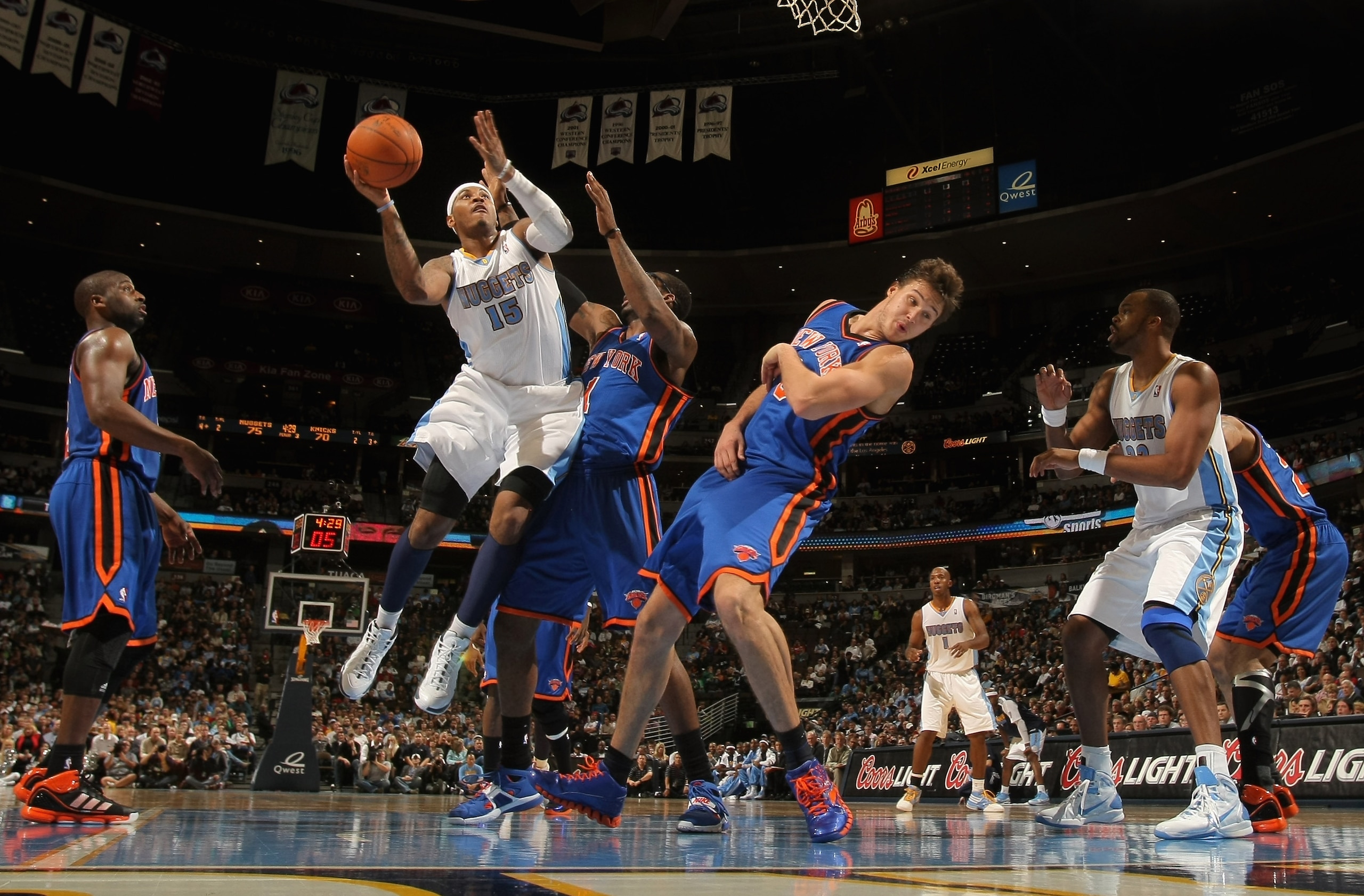 DENVER - NOVEMBER 16:  Carmelo Anthony #15 of the Denver Nuggets puts up a shot over Amar'e Stoudemire #1 and Danilo Gallinari #8 of the New York Knicks at the Pepsi Center on November 16, 2010 in Denver, Colorado. The Nuggets defeated the Knicks 120-118.
